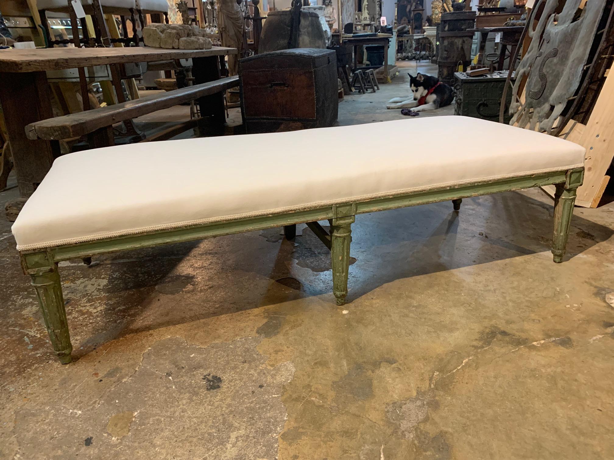 A very stunning and very elegant Louis XVI period banquette from the Provence region of France. Soundly constructed from painted wood with 5 fluted and tapered legs. The central leg to the back is tapered. Recently reupholstered. Wonderful as a