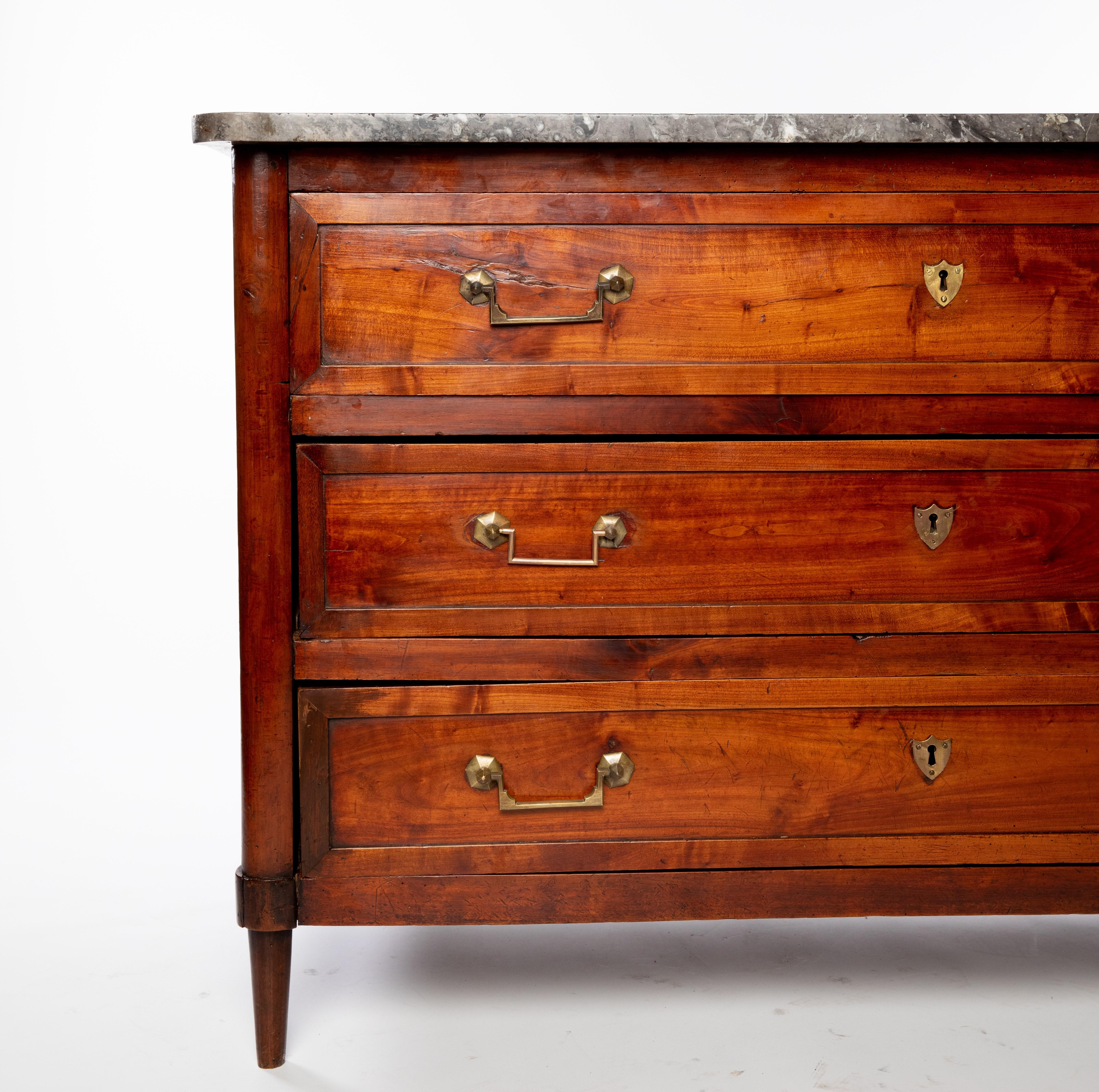 French Louis XVI period marble-top fruitwood commode, late 18th c., shaped marble top, over case fitted with three drawers, rising on tapered legs, (one) foot with restoration.