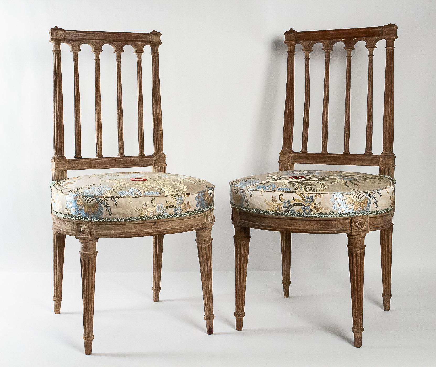 French Louis XVI period, pair of chairs in lacquered beechwood, circa 1780.

An interesting and elegant pair of chairs, with right and waisted assemblies, raised on fluted feet.
These chairs are an explicit reference to the architectural design,