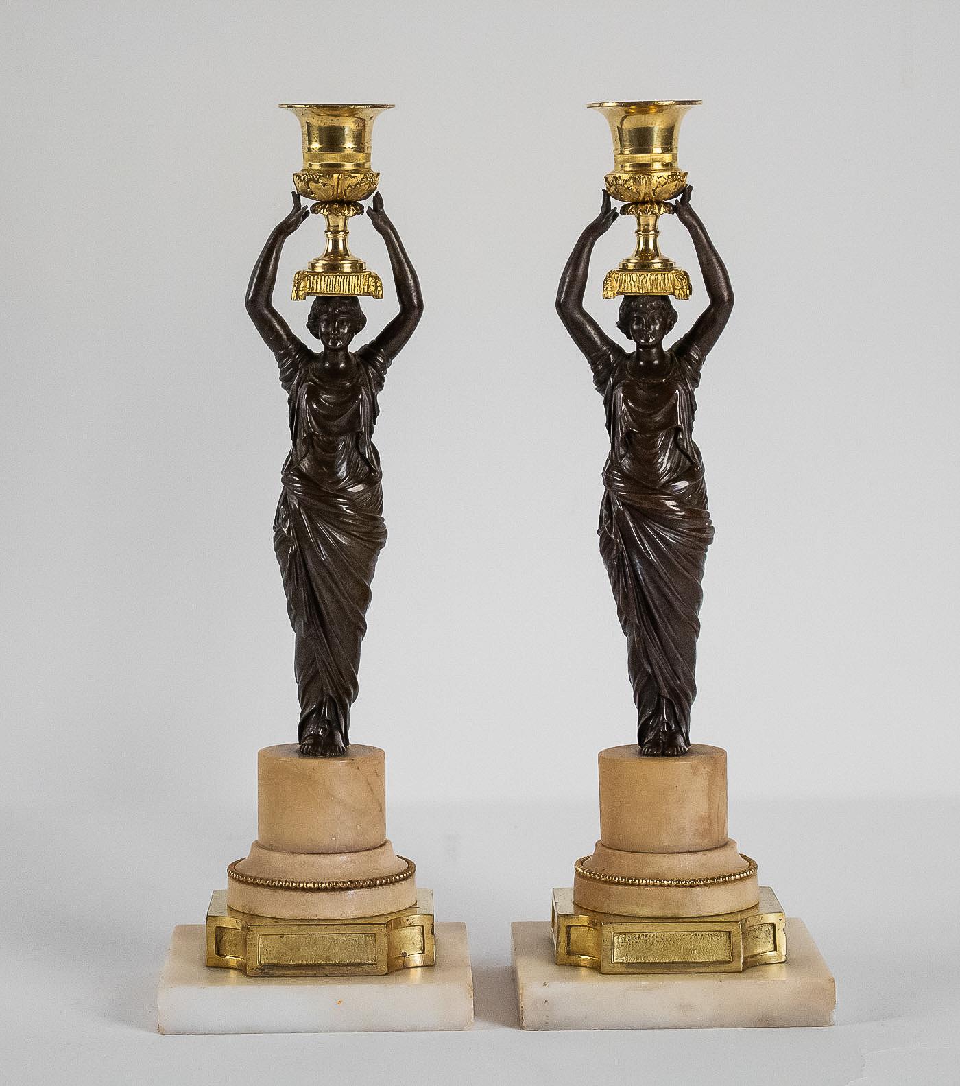 French Louis XVI period, pair of patinated and gilded candlesticks, circa 1780.

Unique pair of finely chiseled mercury-gilt and patinated bronze candlesticks depicting antique female maidens, resting on gilt bronze and, Sienna and Carrara marble