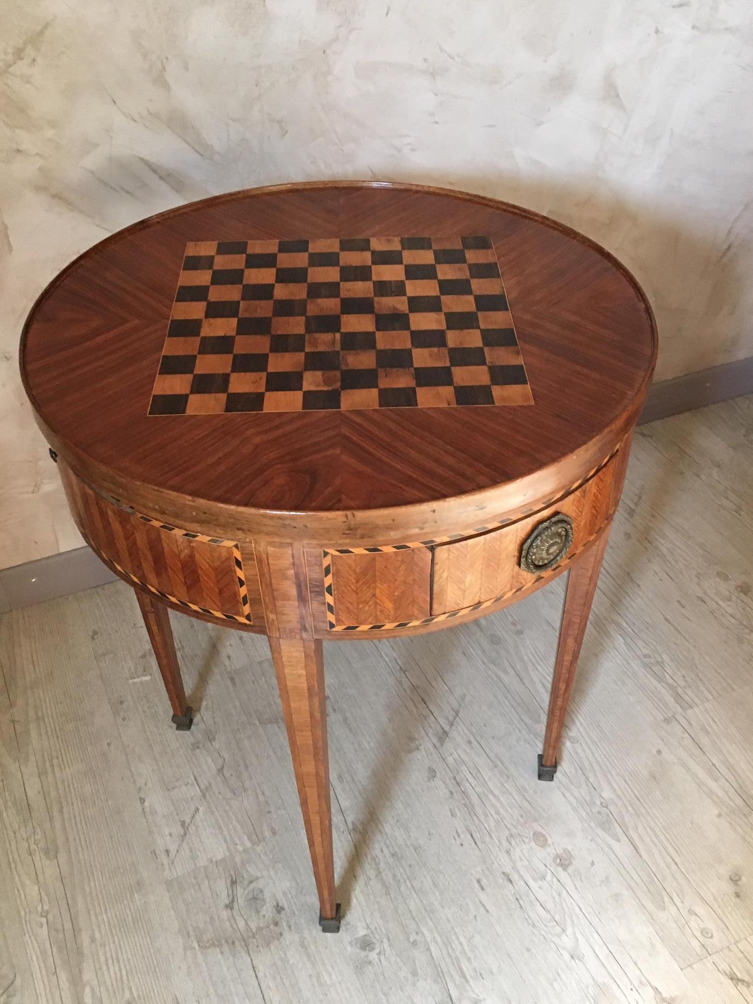 Exceptional and rare late 18th century Louis XVI period table with a beautiful marquetry landscape on the top. This top is removable and reversible and offer a perfect playing table on the other side.
Below, you will find a nice red leather that