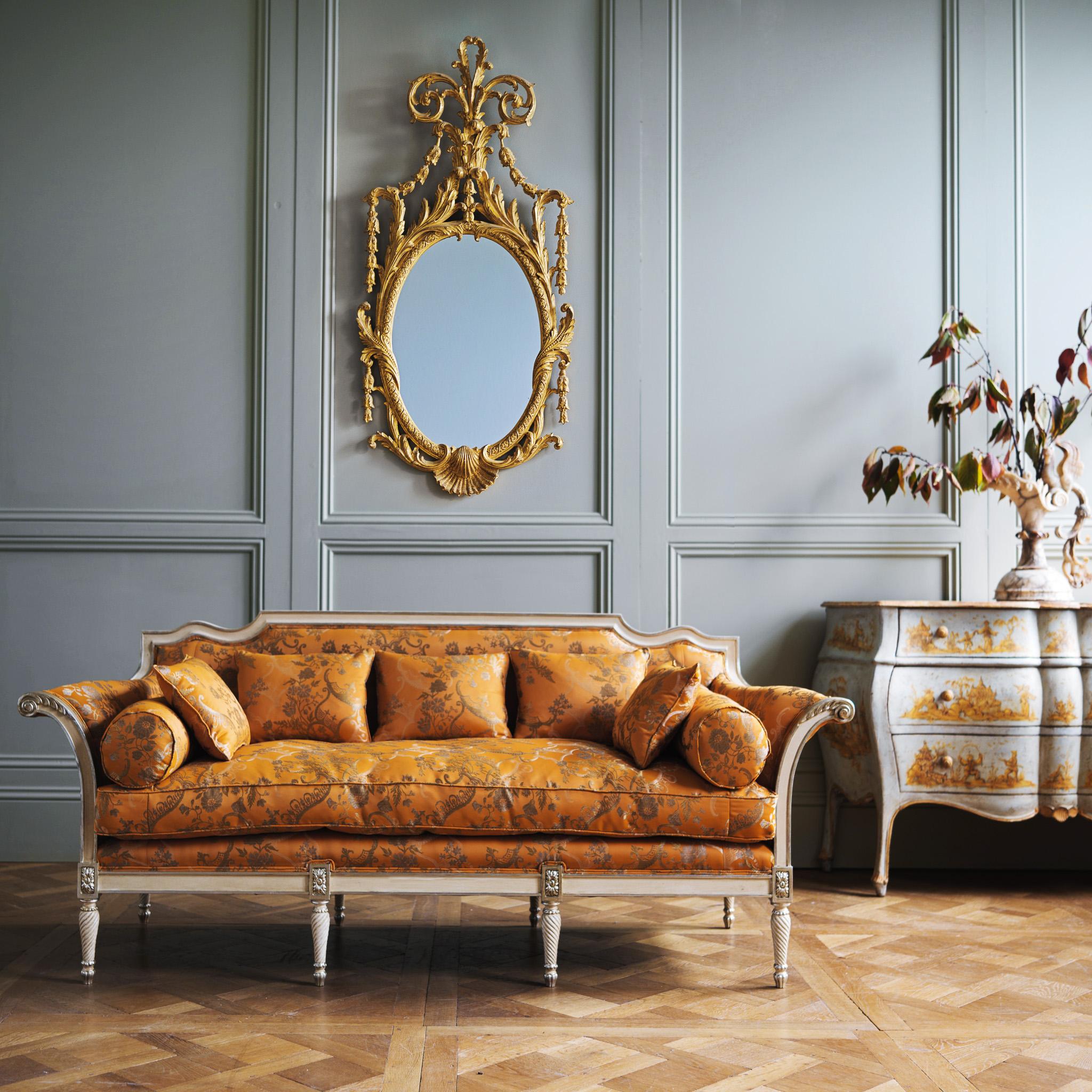Französisches Sofa im Louis XVI-Stil mit geschwungenen Armen, handgeschnitzt von La Maison London. Dieses Stück wurde in unserem Haus in einem Ecru-Weiß mit handvergoldeten Highlights fertiggestellt. Die Sitz-, Nacken- und Streukissen sind mit