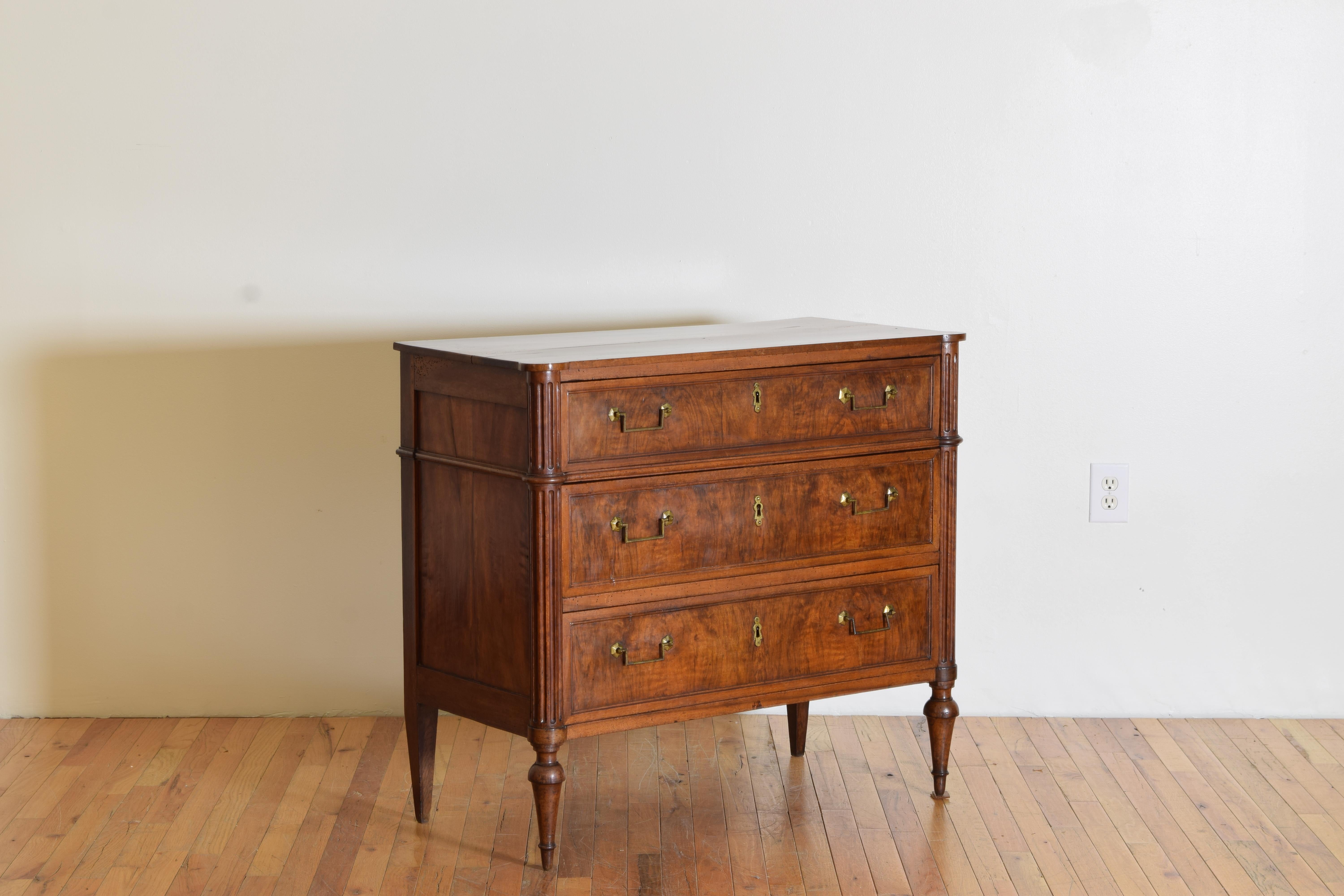 Having a rectangular top with roundel corners above a conforming case housing three drawers, retaining period brass hardware, the case with fluted roundel corners and horizontal side moldings, raised on shaped tapering feet.