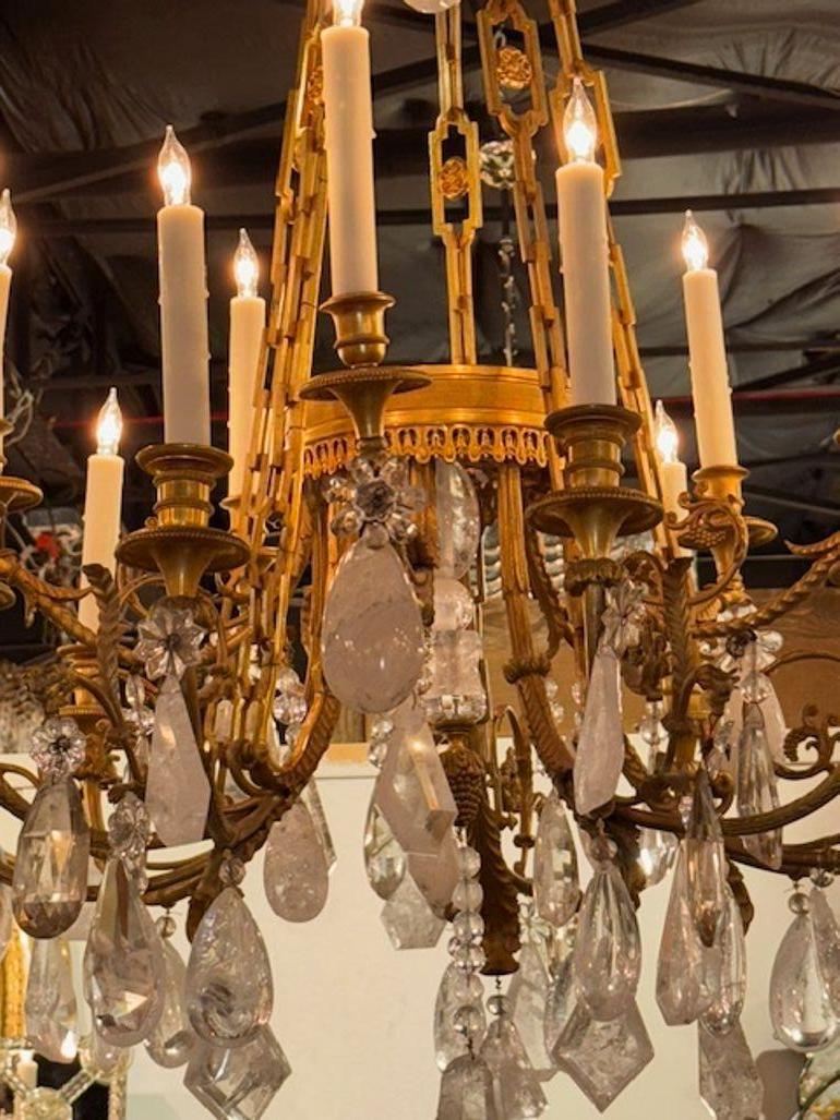 Raffinato lampadario a 16 luci in bronzo dorato e cristallo di rocca Luigi XVI del XIX secolo. Circa 1870. Il lampadario è stato ricablato professionalmente e viene fornito con catena e baldacchino coordinati. È pronto da appendere! 49h x 32w