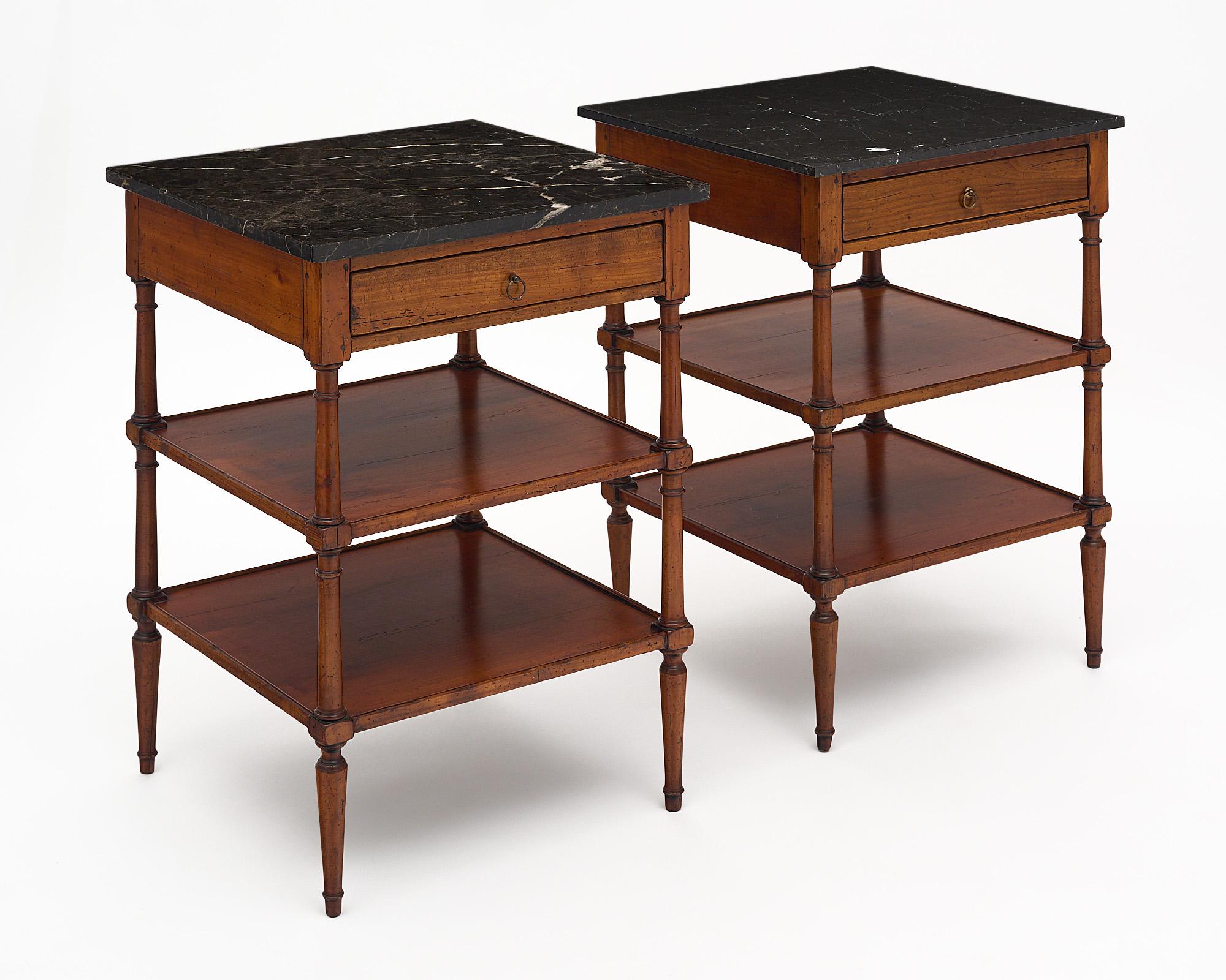 French pair of Louis XVI style side tables from the enchanting Rhone Valley. These tables are made of mahogany; and feature an intact black marble top with one dovetailed drawer.