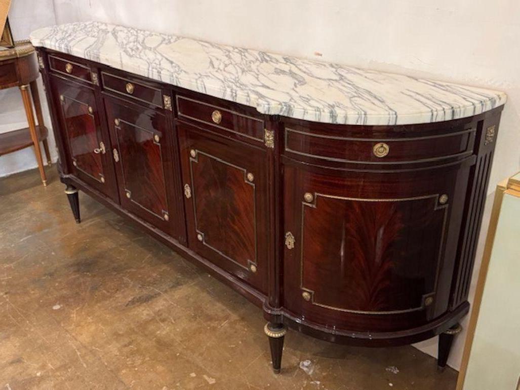 Fine quality French Louis XVI style flame mahogany D shape sideboard. French Louis XVI–style flame mahogany D-shape sideboards are prized for their curved silhouettes, rich wood grain, and gilt accents. Circa 1940. 98w x 19.5d x 39.5h 