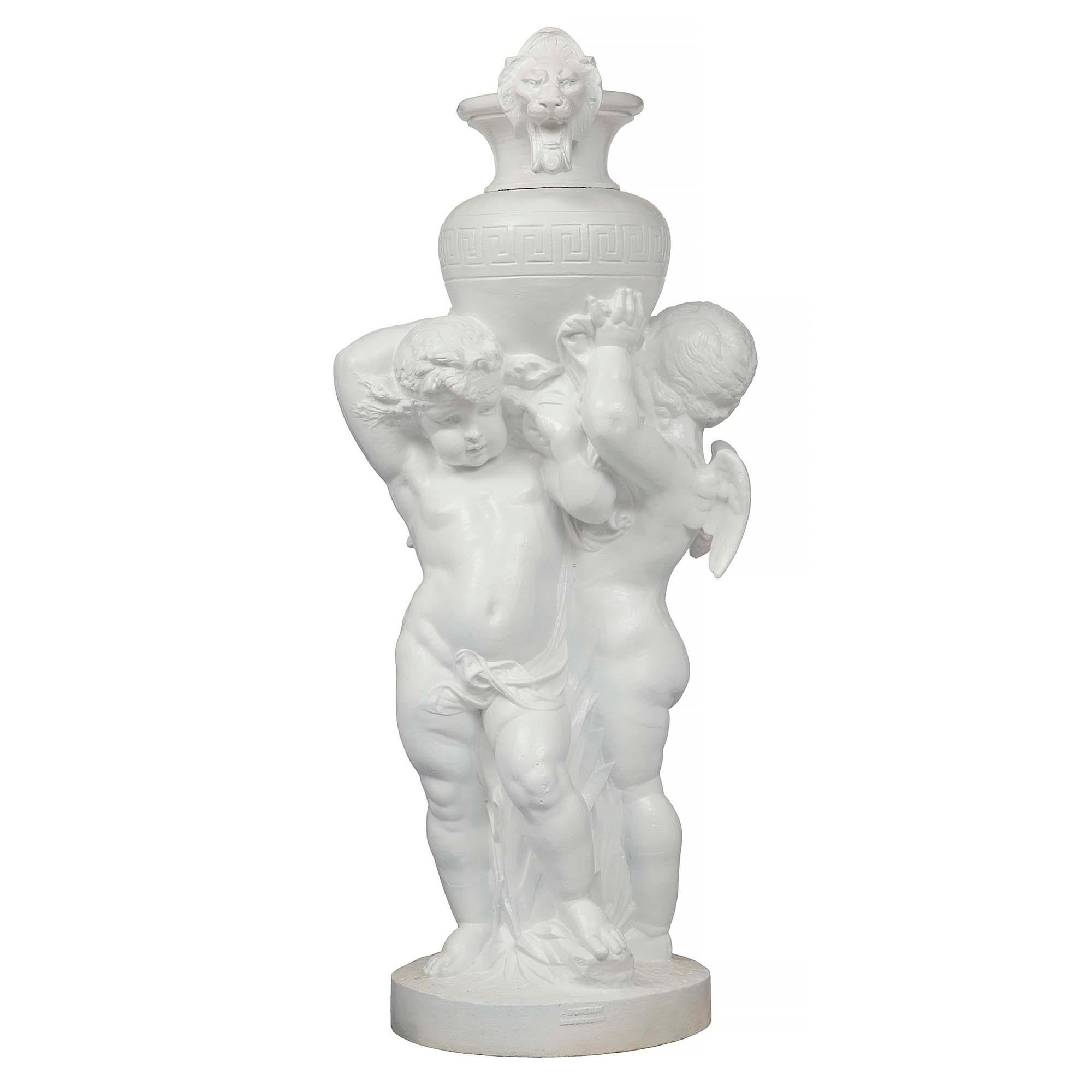 A large-scaled and most charming French 19th century Louis XVI st. cast iron grouping of two winged cherubs holding an urn. The cast iron statue is signed Antoine Durenne in the front and signed a second time in the back. One cherub looking in one