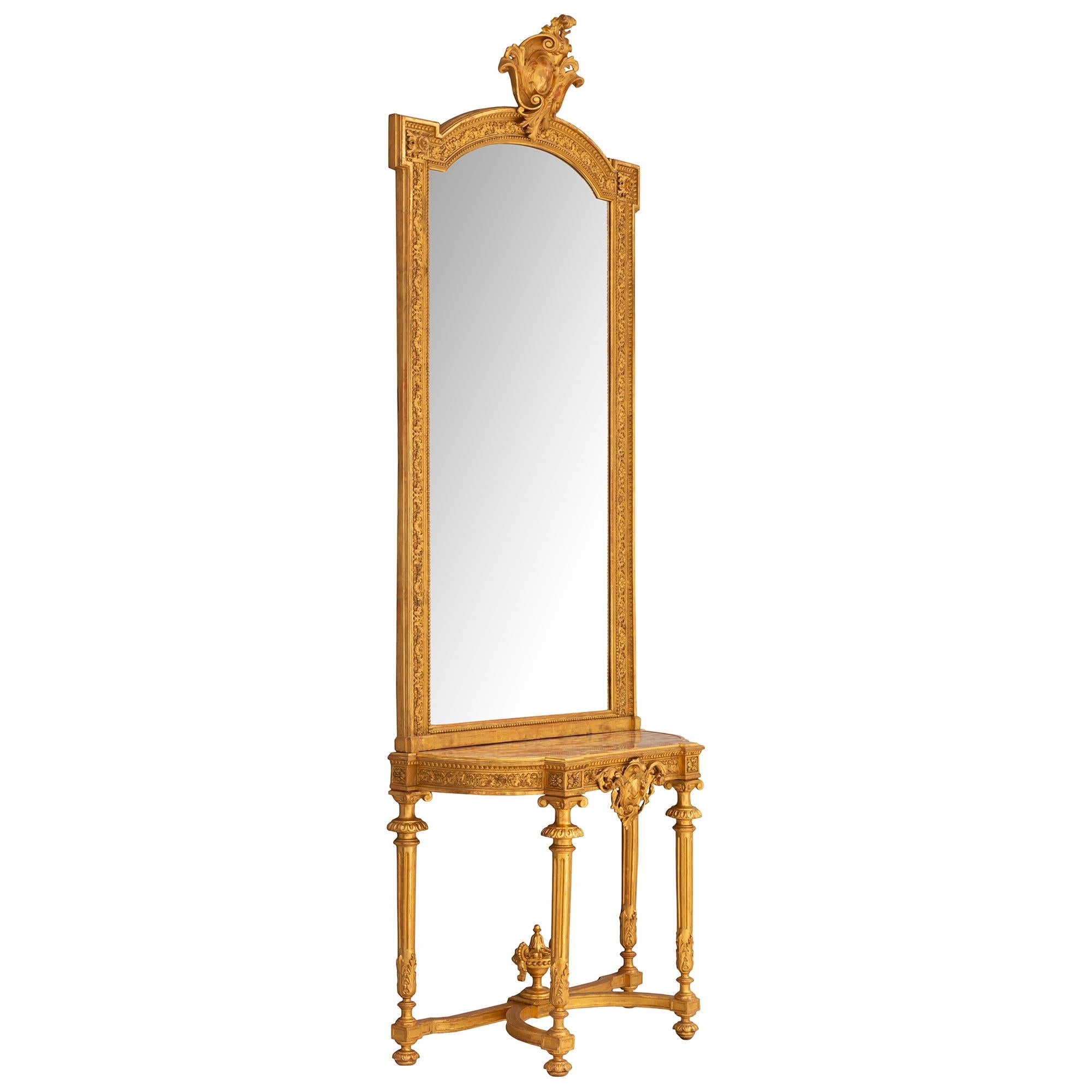 A stunning French Louis XVI st giltwood console with original matching mirror. The console is raised on carved bun feet with reeded legs decorated with acanthus leaves and top capitols. The legs are joined with a stretcher with a wonderful carved
