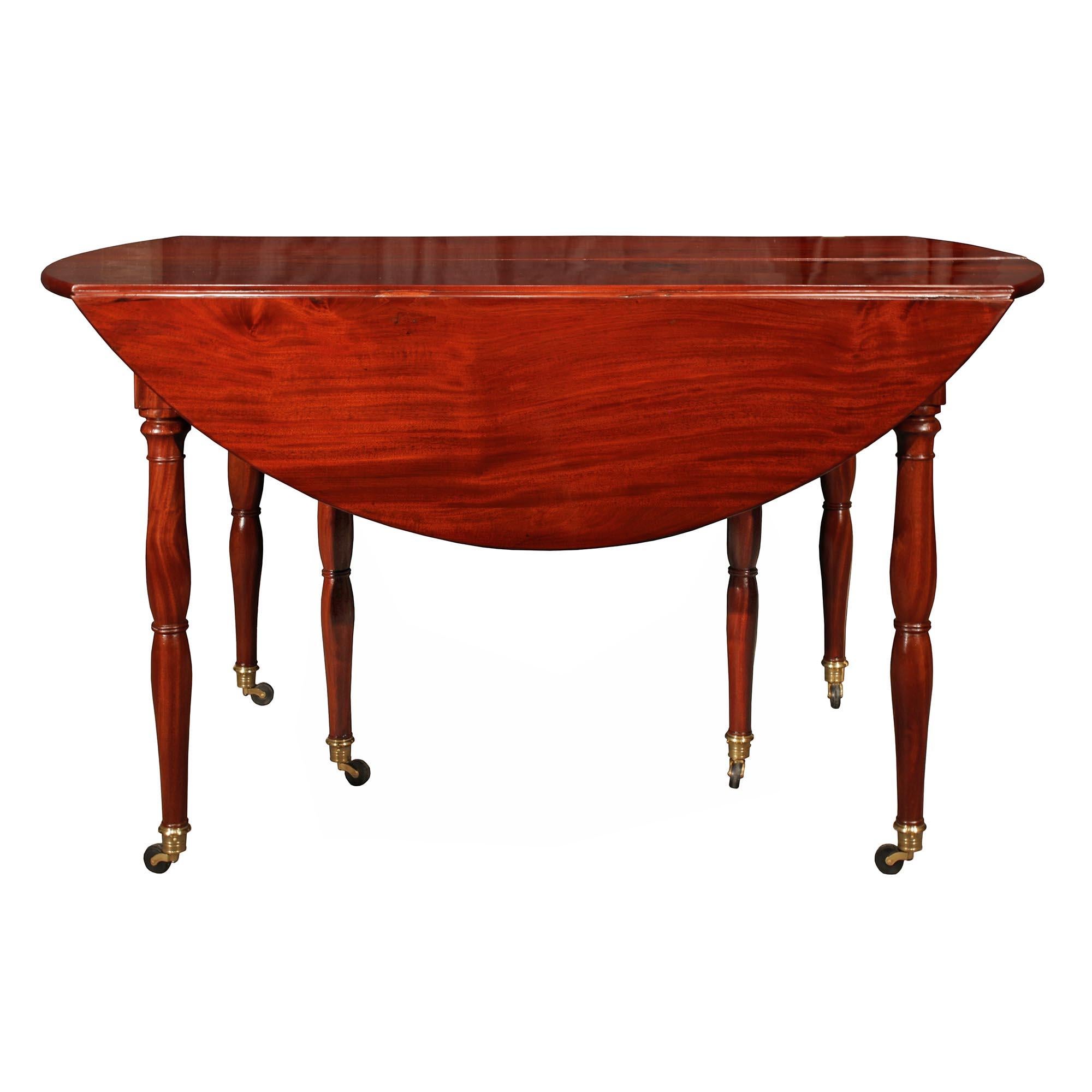 A handsome French Louis XVI st. mahogany drop leaf dining table. The table is raised on six original brass casters below the tapered baluster shaped legs. Rich warm grain and patina throughout and with three extensions measuring 21.5 each.