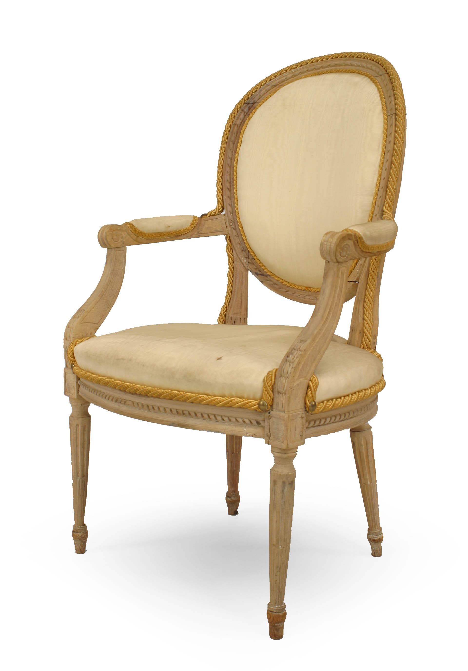 Set of 10 French Louis XVI stripped bleach dining chairs with white silk upholstered oval back & seat over fluted turned legs. 2 arm, 8 side chairs, circa 1775.