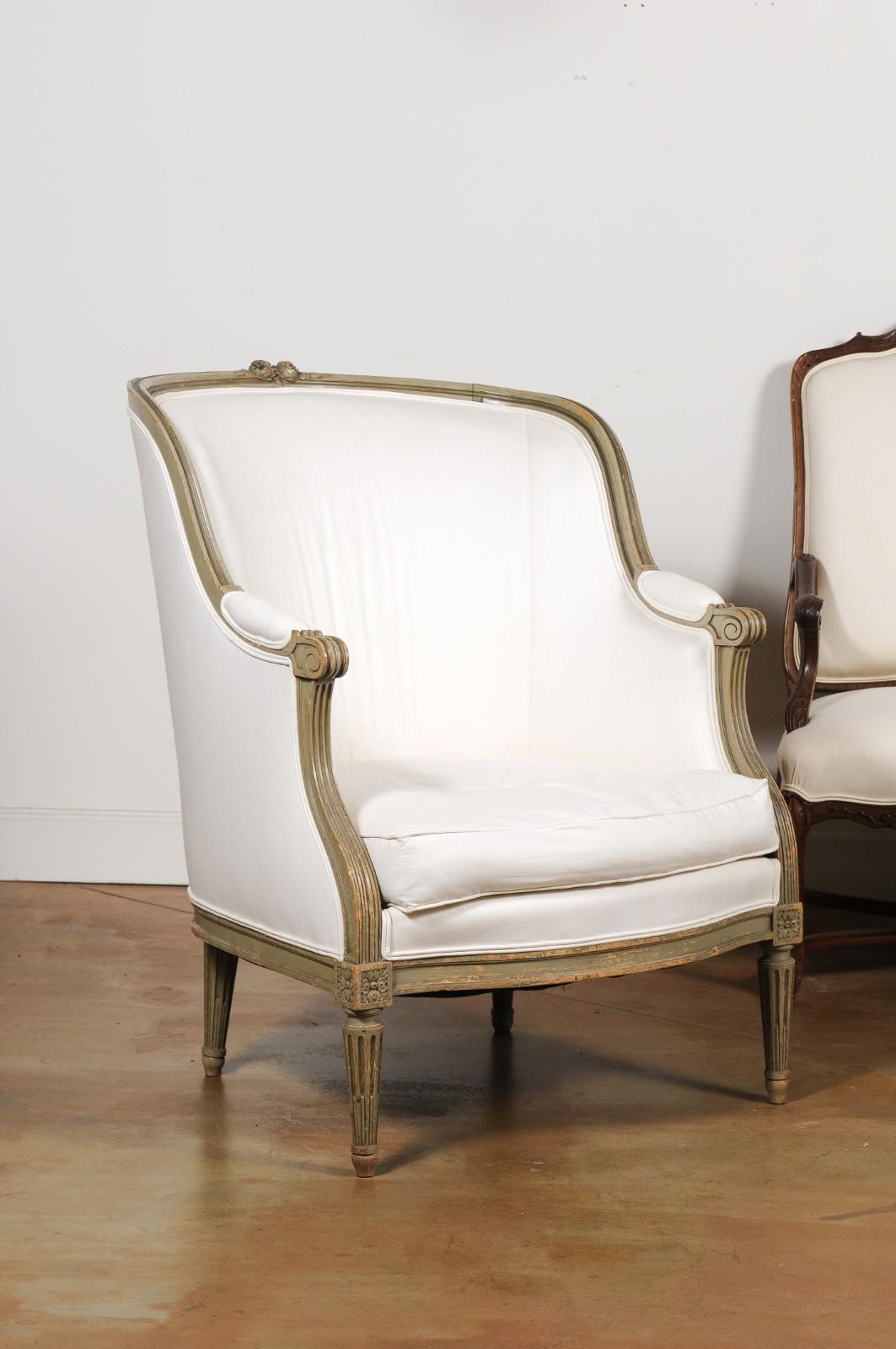 A French Louis XVI style barrel back bergère chair from the late 19th century, with new upholstery. Born in France during the last quarter of the 19th century, this bergère chair features a barrel back accented with two delicate roses and their