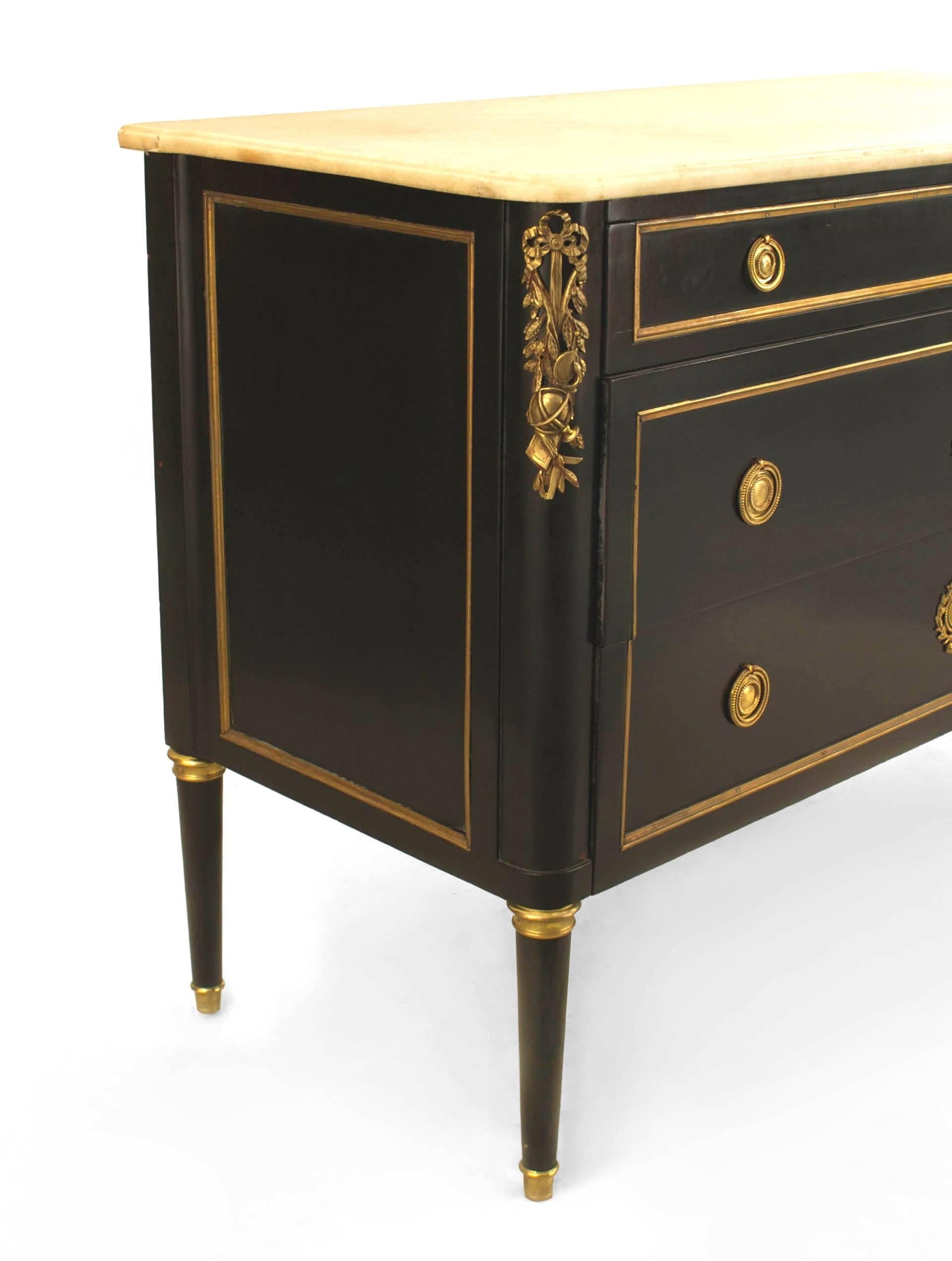 French Louis XVI style (1940s) ebonized gilt and bronze trimmed chest with 2 large drawers under a smaller drawer having ring handles with a white marble top. (stamped: JANSEN)
