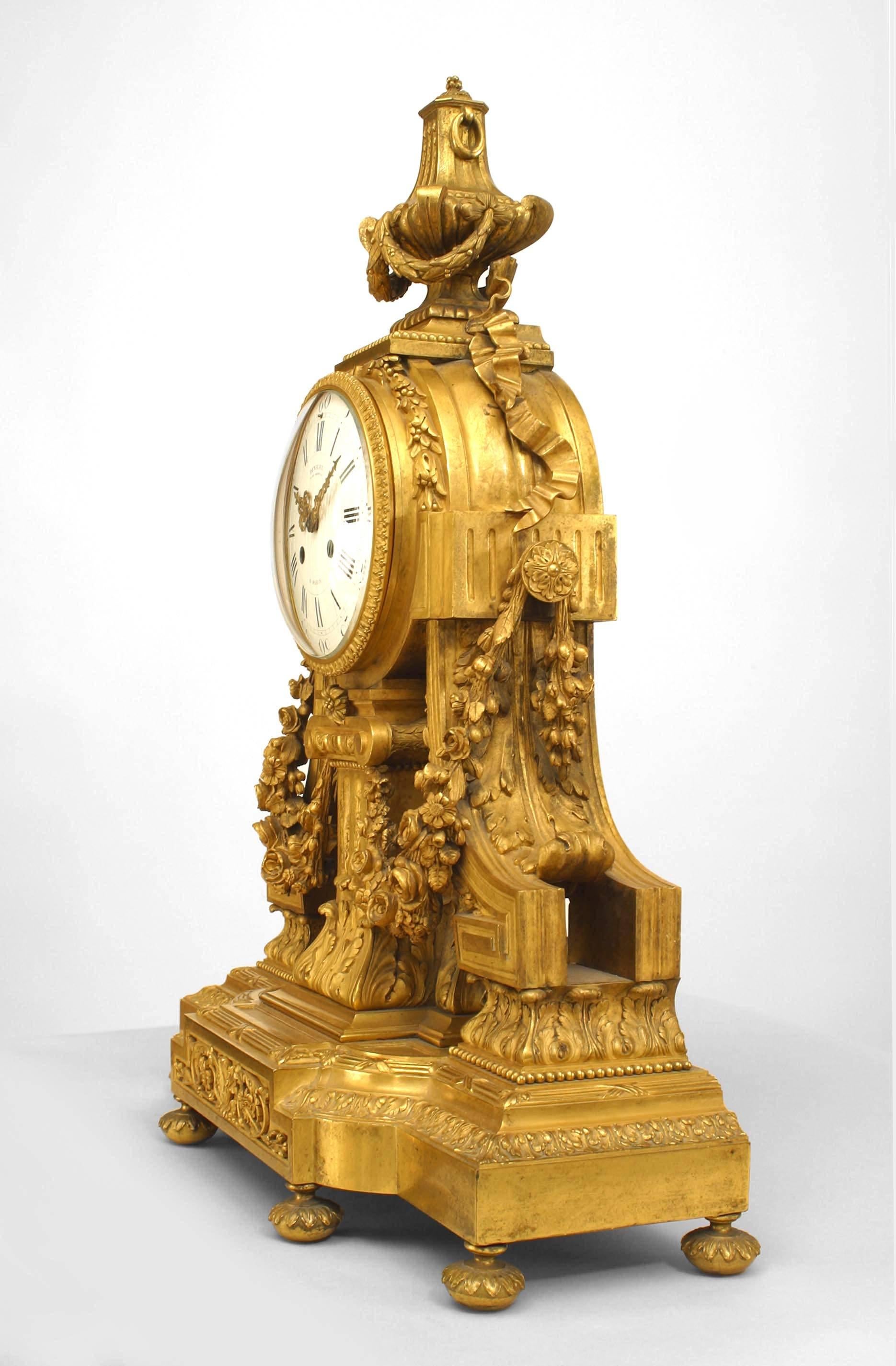 French Louis XVI-style (19th Century) gilt bronze mantle clock with a center fluted column supporting the clock face draped with a garland and an urn finial top (signed: DENIERE, PARIS) (Not working)
