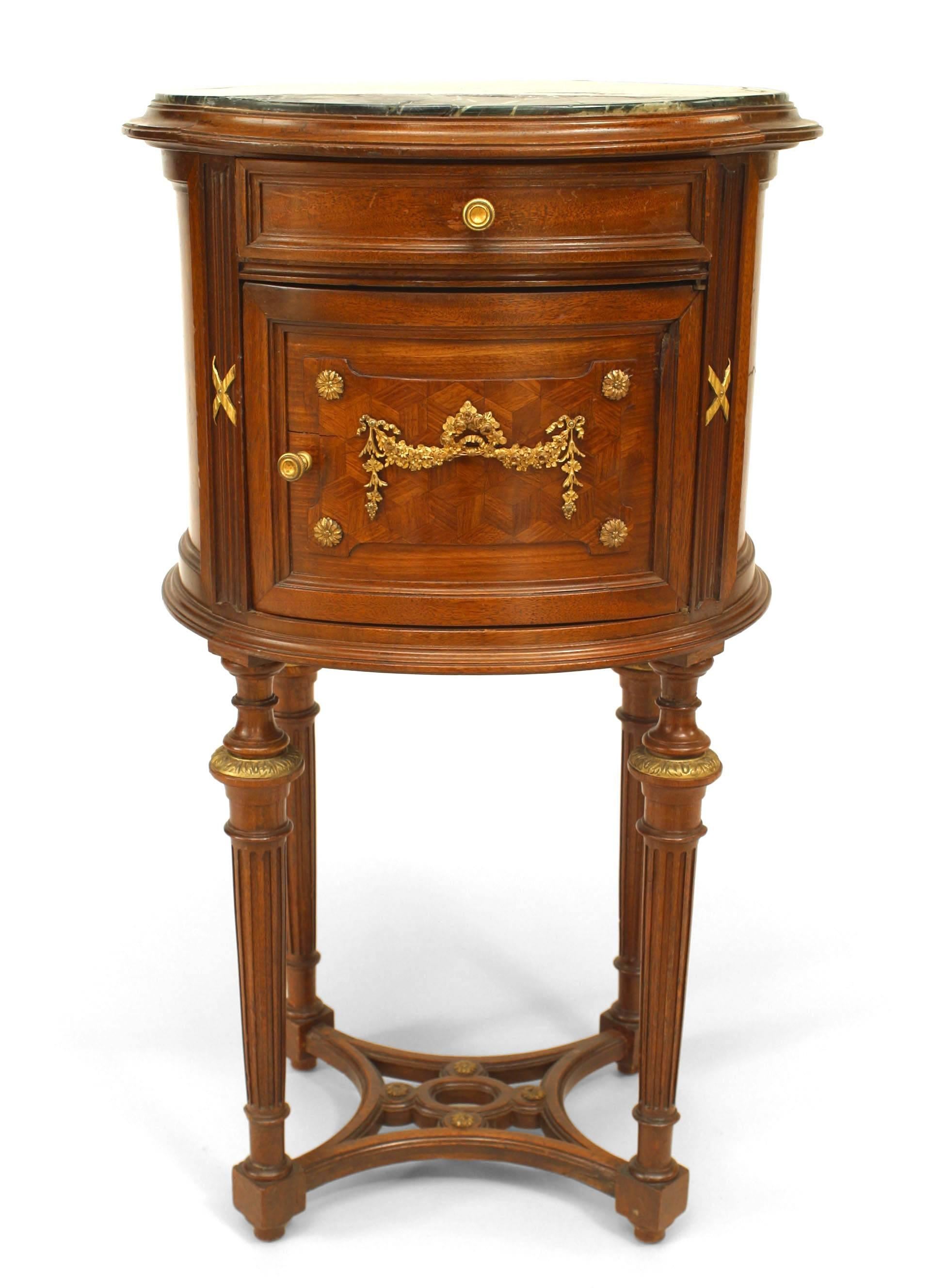 French Louis XVI-style (19th Century) oval mahogany bedside commode with open stretcher and green marble top.
