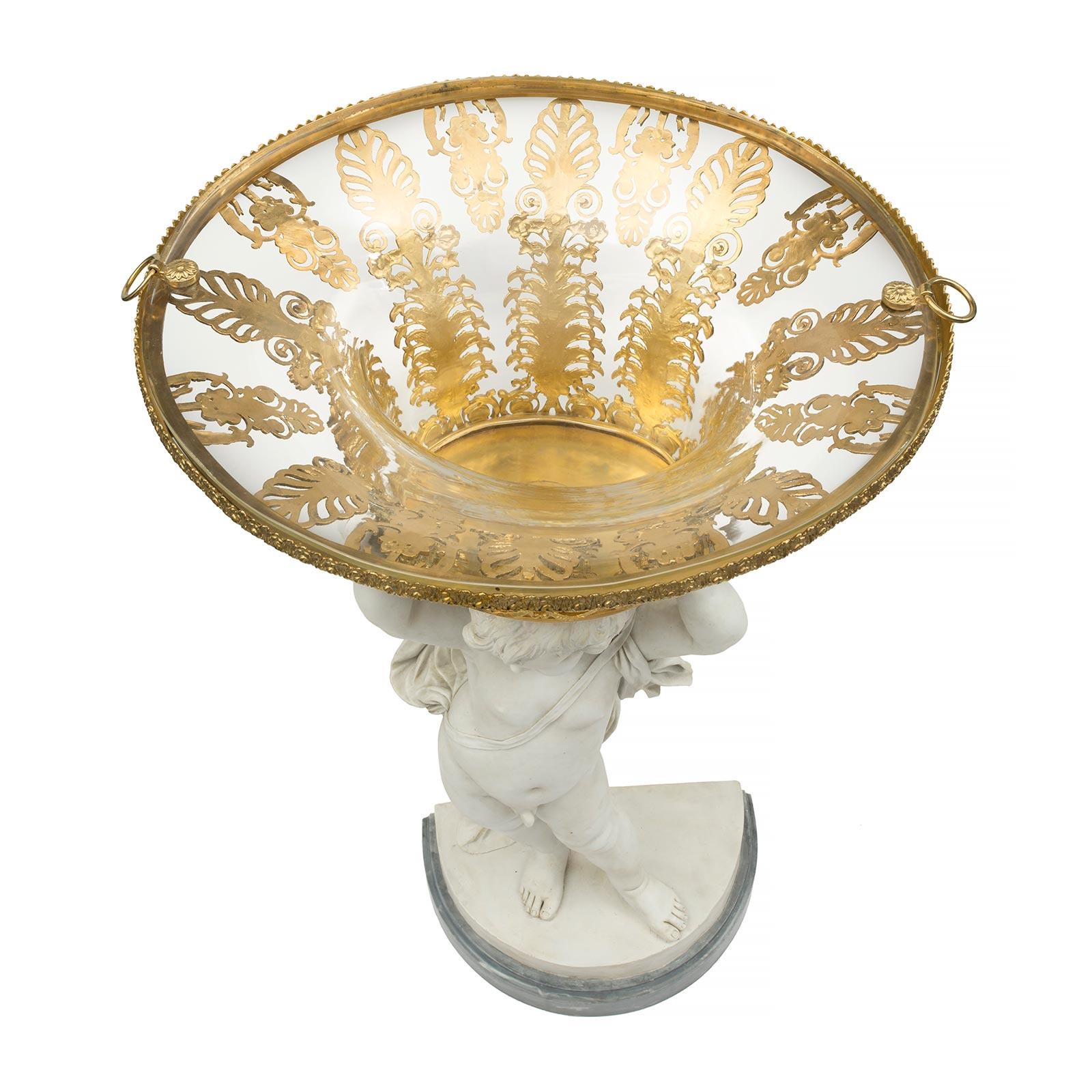 A very elegant and unique French 19th century Louis XVI st. Biscuit de Sèvres porcelain, ormolu and crystal centerpiece signed Louis-Simon Boizot. The centerpiece is raised by a thick demi lune Gris St. Anne marble base with a concave top border.