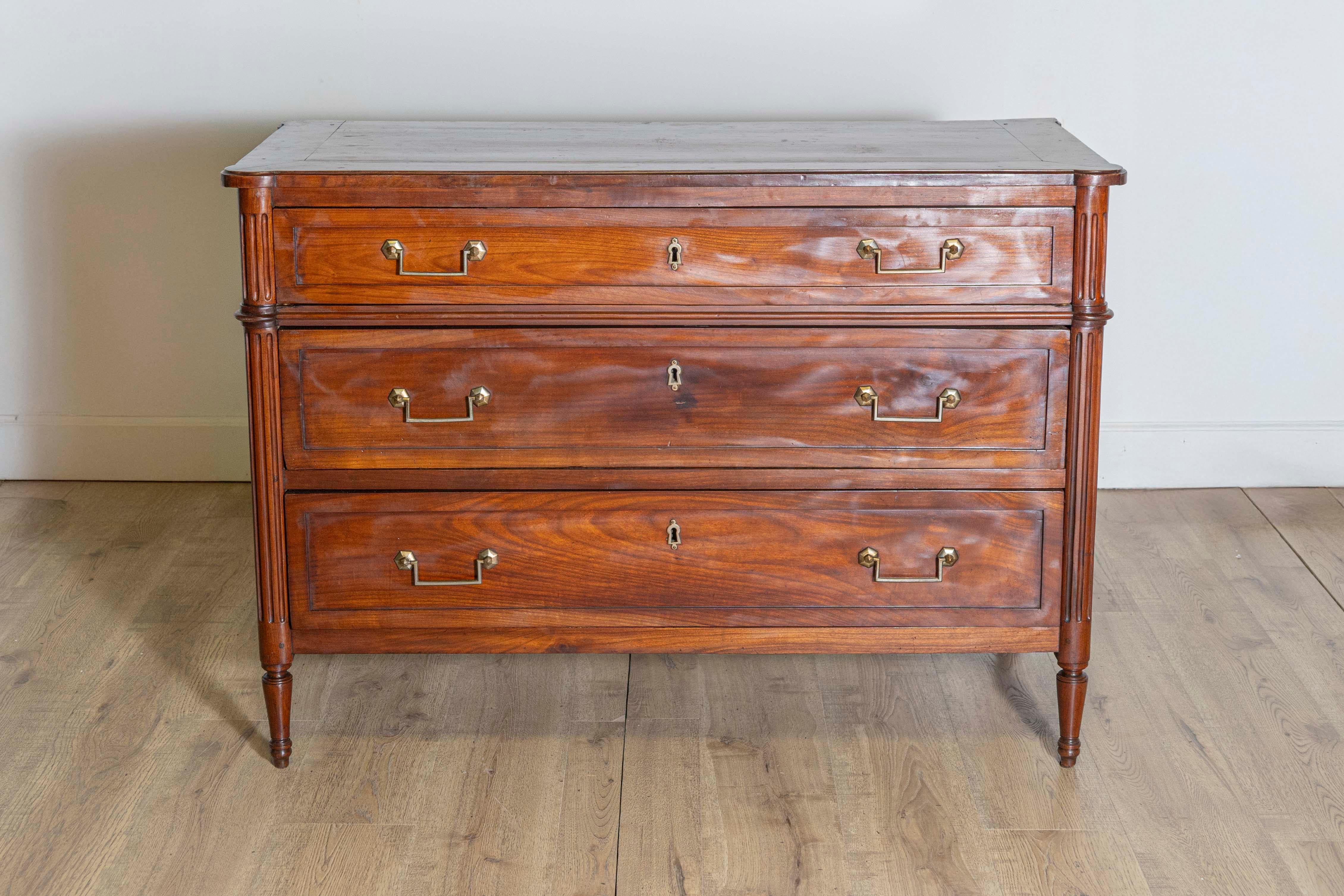 Commodo francese in ciliegio in stile Luigi XVI del XIX secolo, con tre cassetti graduati, ferramenta lineare in ottone, montanti laterali scanalati e gambe cilindriche affusolate. Creata in Francia nel XIX secolo, questa commode in ciliegio