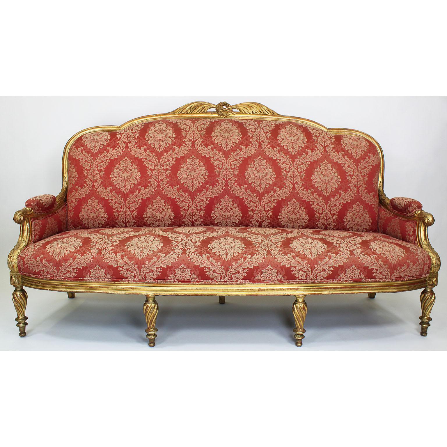 A fine French Louis XVI style 19th century giltwood carved three-piece salon suite, comprising of a three-corps settee and two armchairs, Paris, circa 1890.

Measures: Settee height 46 1/2 inches (118.1 cm)
Settee width 79 inches (200.7