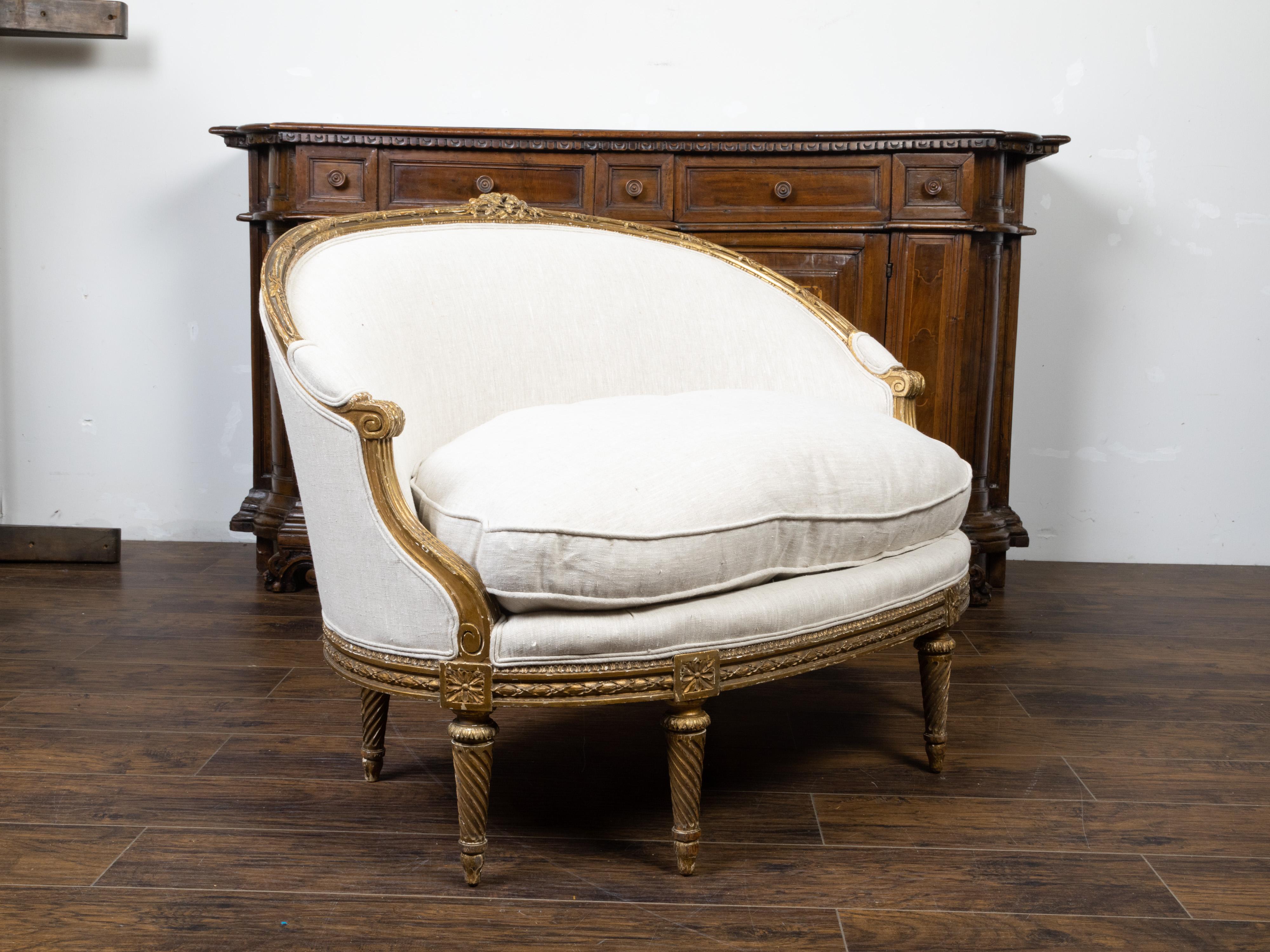 A French Louis XVI style giltwood canapé en corbeille from the 19th century, with carved flowers and new upholstery. Created in France during the 19th century, this gilded canapé features a wraparound back topped with carved flowers, while two