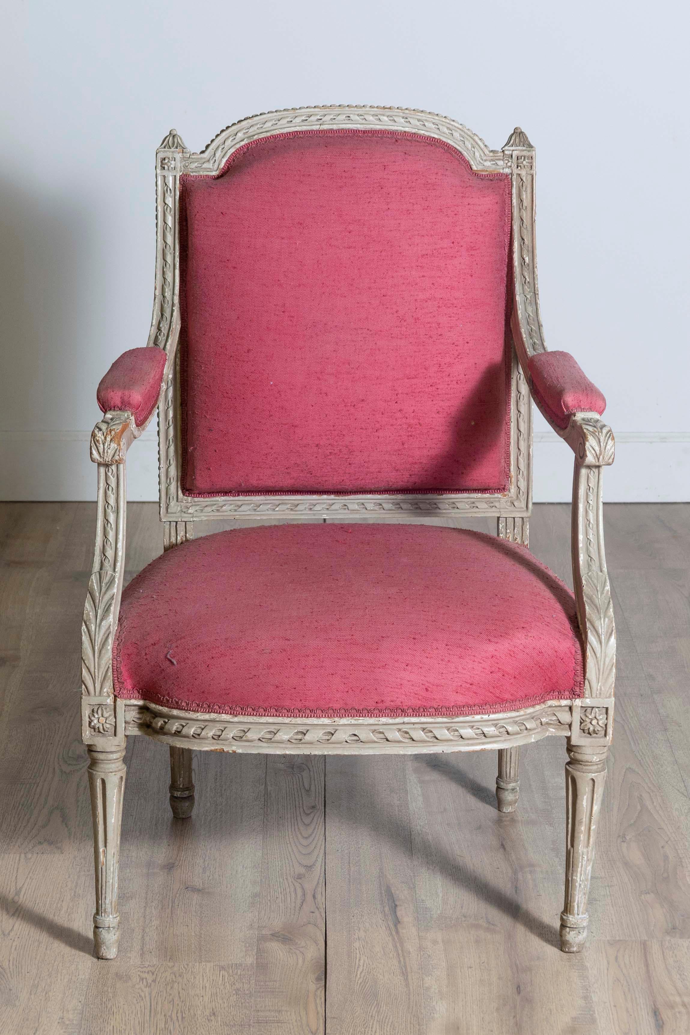 Fauteuil français en bois peint de style Louis XVI, datant du XIXe siècle, avec un décor sculpté comprenant des motifs de corde torsadée, des feuilles d'acanthe, des rosettes et des petites perles. Entrez dans l'ère de l'élégance française avec ce