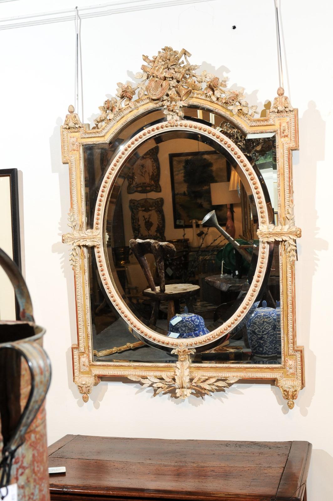 A French Louis XVI style parcel-gilt and painted wood mirror 