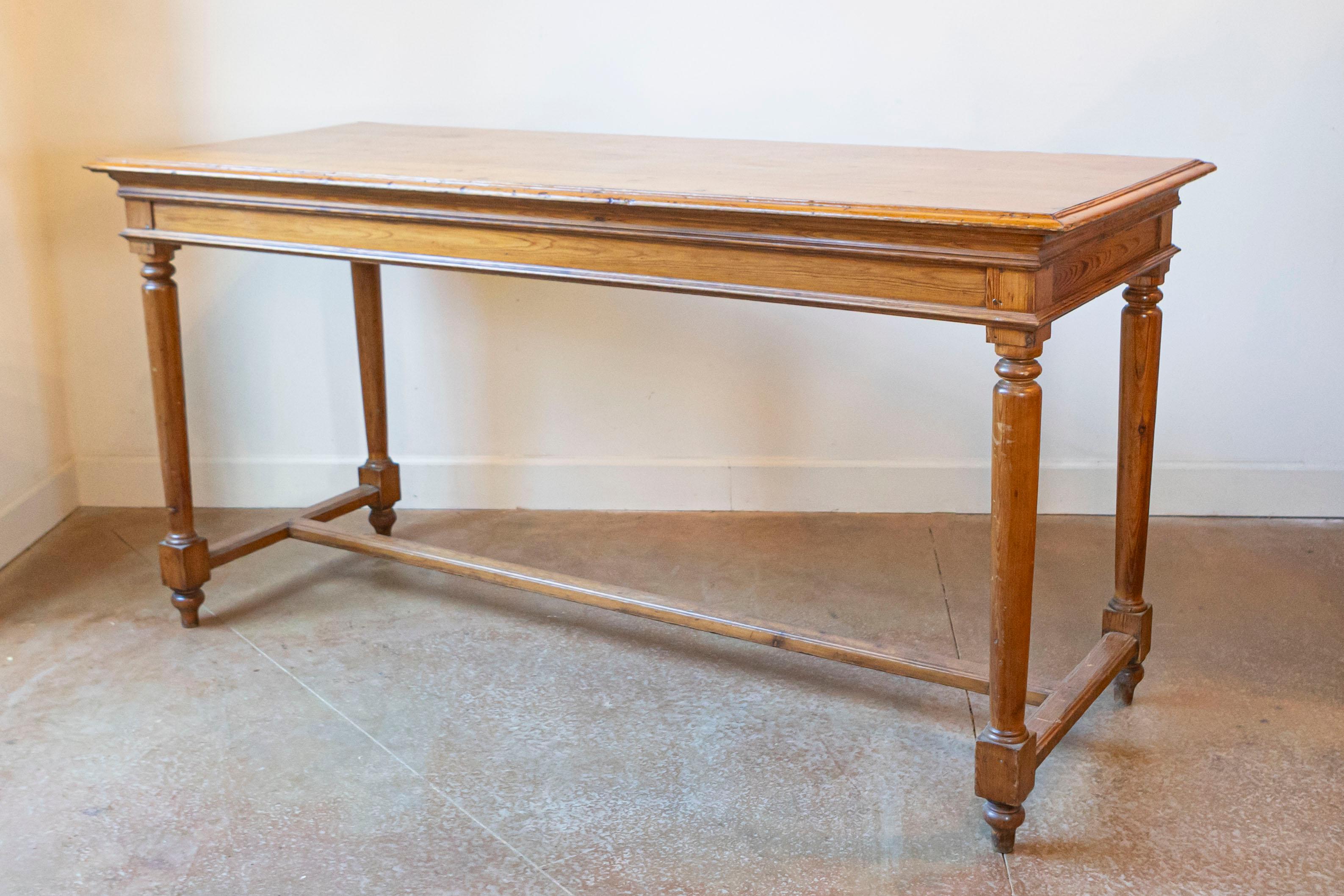 Mesa alta francesa de pino del siglo XX, estilo Luis XVI, con patas cilíndricas ahusadas, pies en forma de toupie y travesaño en forma de H. Creada en Francia durante el siglo XX, esta mesa de bar de pino presenta las características estilísticas de