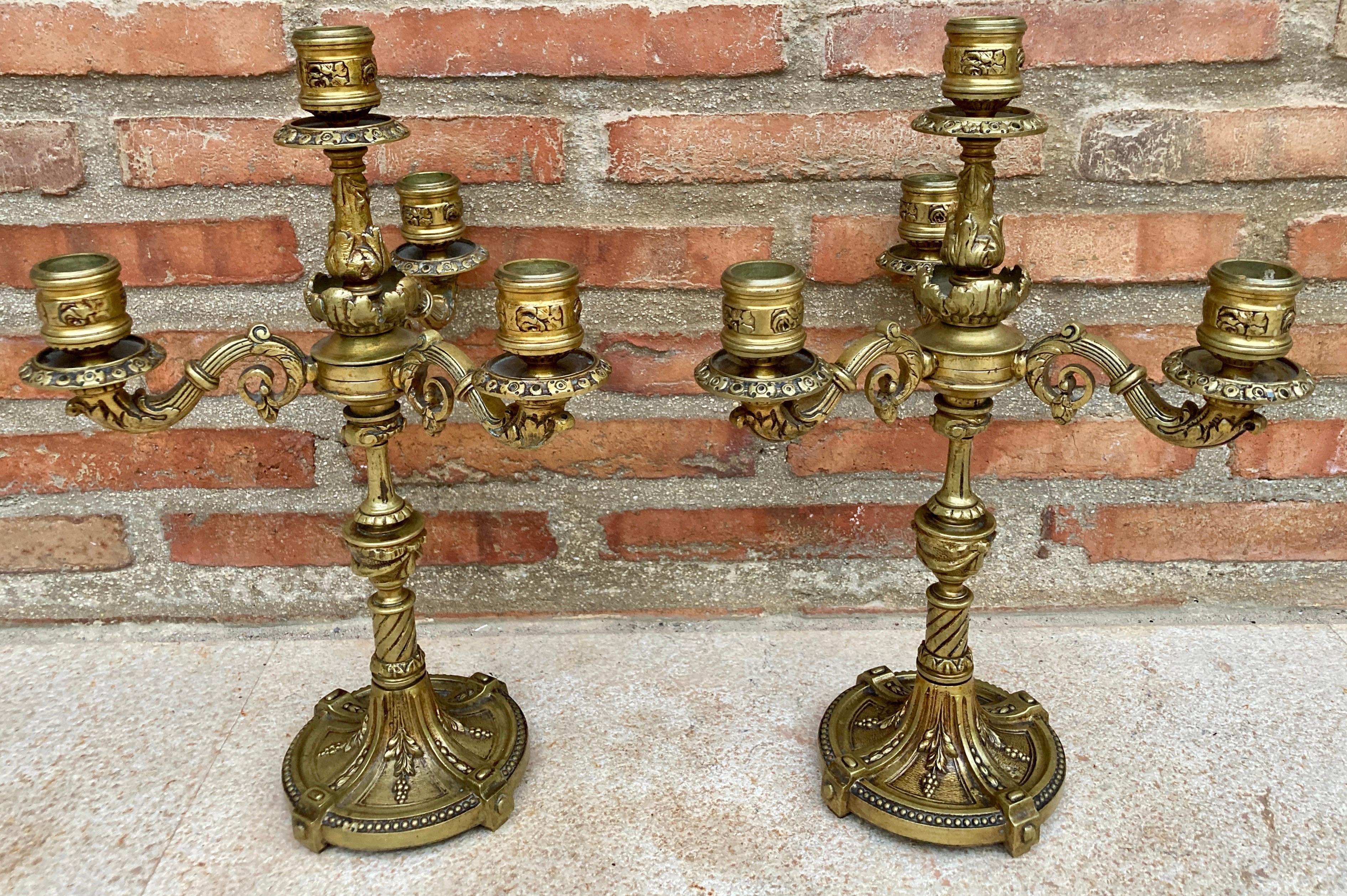A pair of four-light gilt bronze Louis XVI style candelabra or table lamps.

Each one with a fluted shaft that supports the central light and emits four swept branches. They are not currently wired for electricity, they can be plugged in.