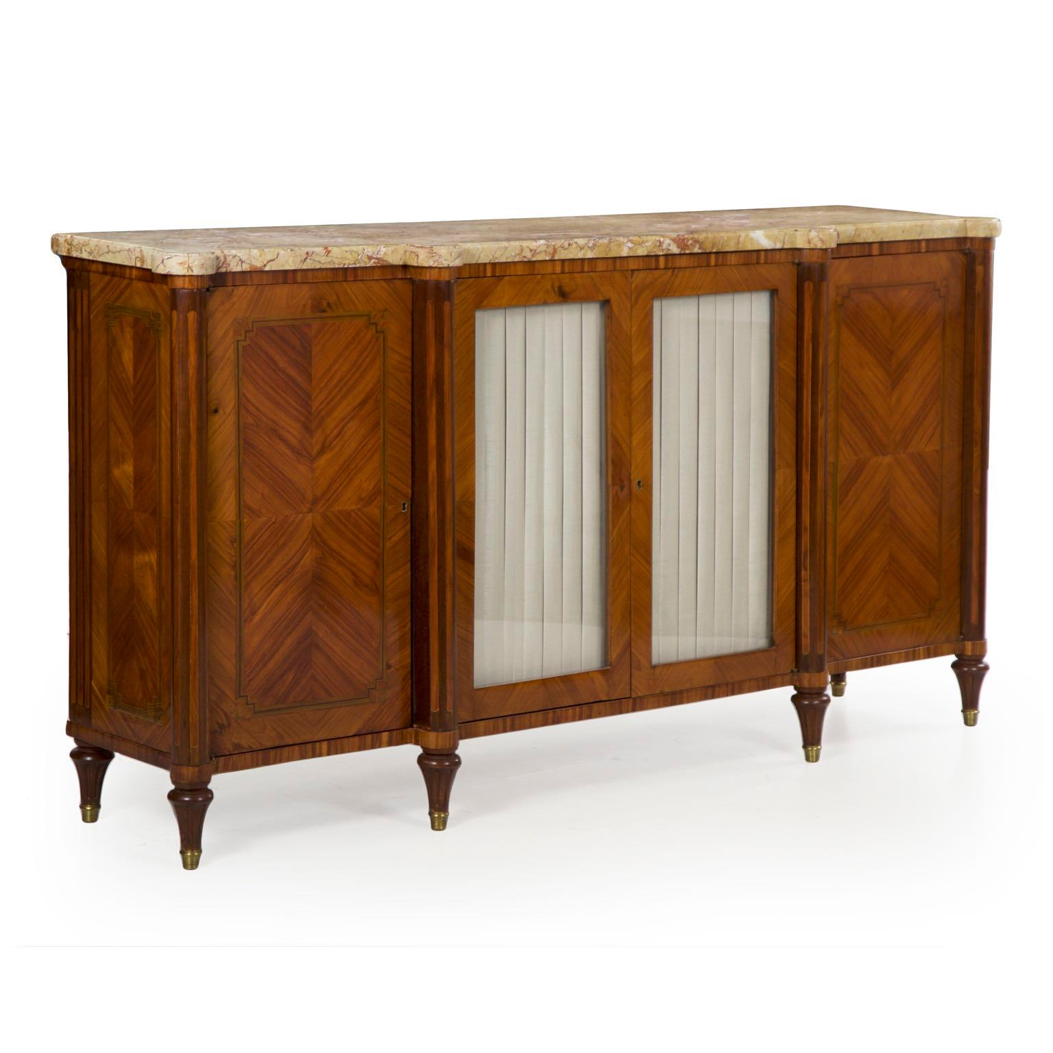 This beautiful French Louis XVI style server is a product of the last quarter of the 19th century, carefully inlaid with matched grain marquetry displays in the doors and exotic fruitwood set in pleasing angular arrays. The thick marble top is