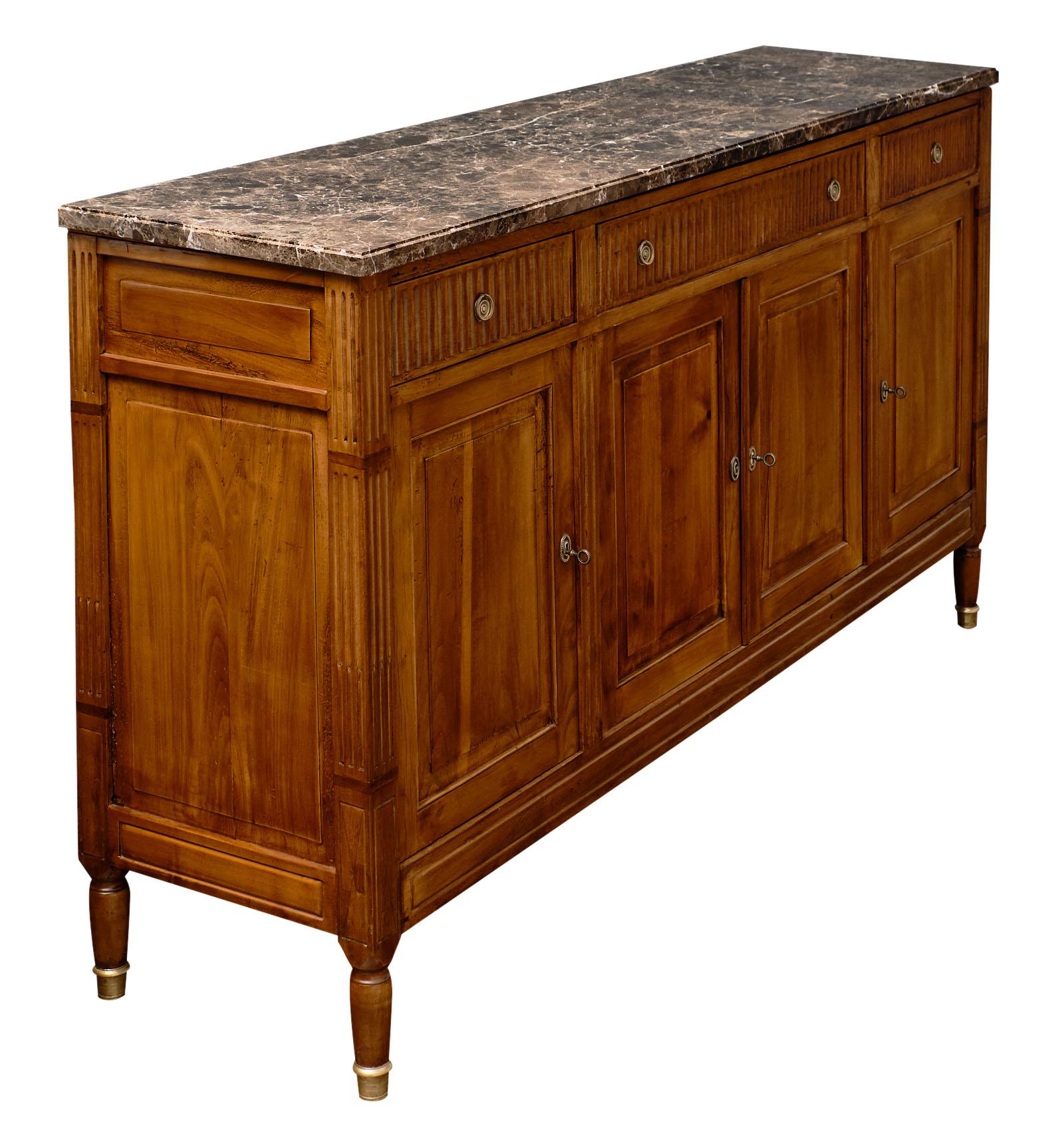 French antique Louis XVI style walnut buffet. This piece is made of figured blonde walnut wood from the Rhone Valley with hand carved details throughout. We love this Classic credenza’s dovetailed drawers and four doors opening to adjustable