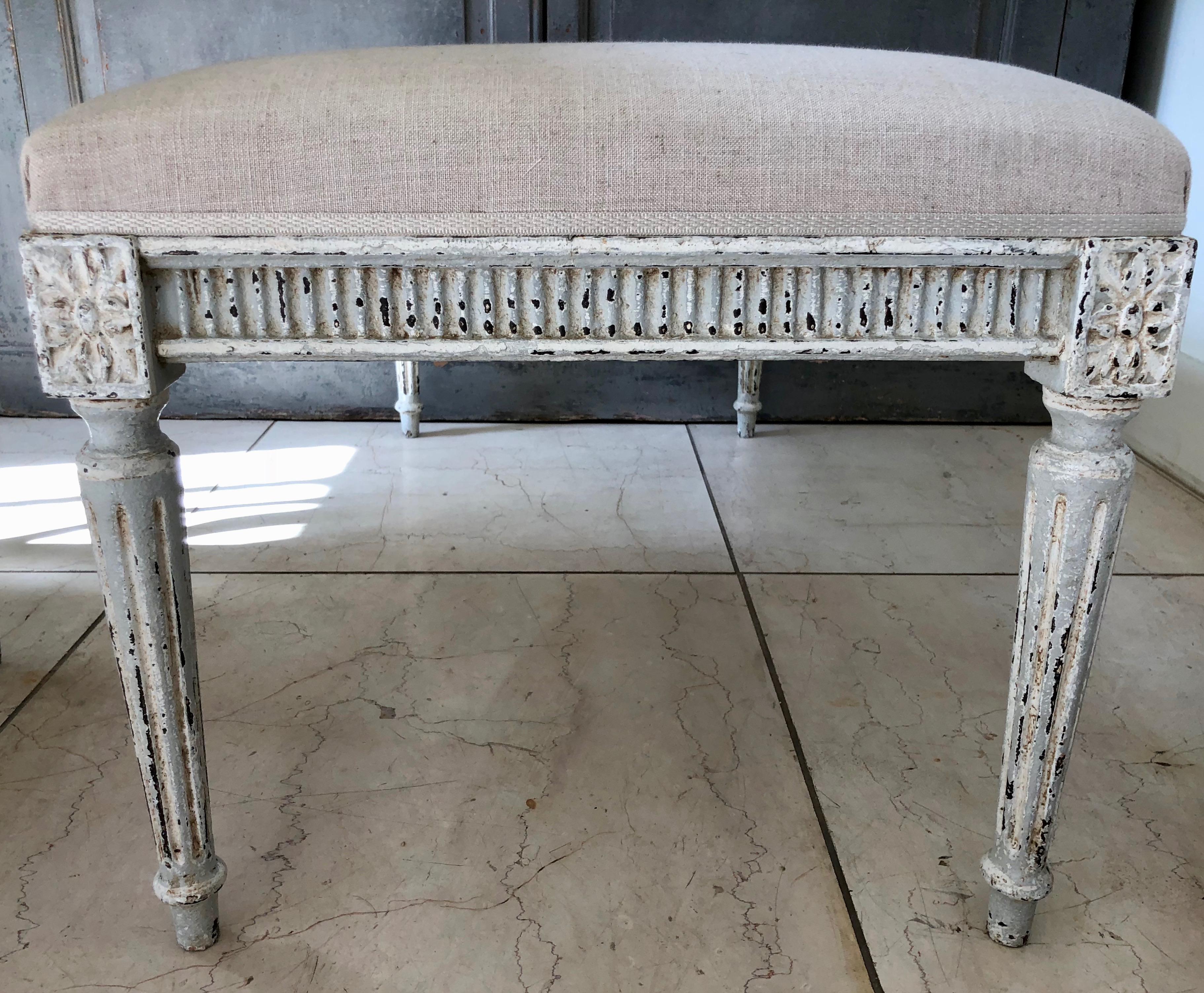 Charming painted bench in Louis XVI style, with legs conical flutings and joining dies decorated with a classical daisy motifs. Upholstered in linen with traditional trimming. Ideal for end of beds or hall way, France, circa 1900.
 