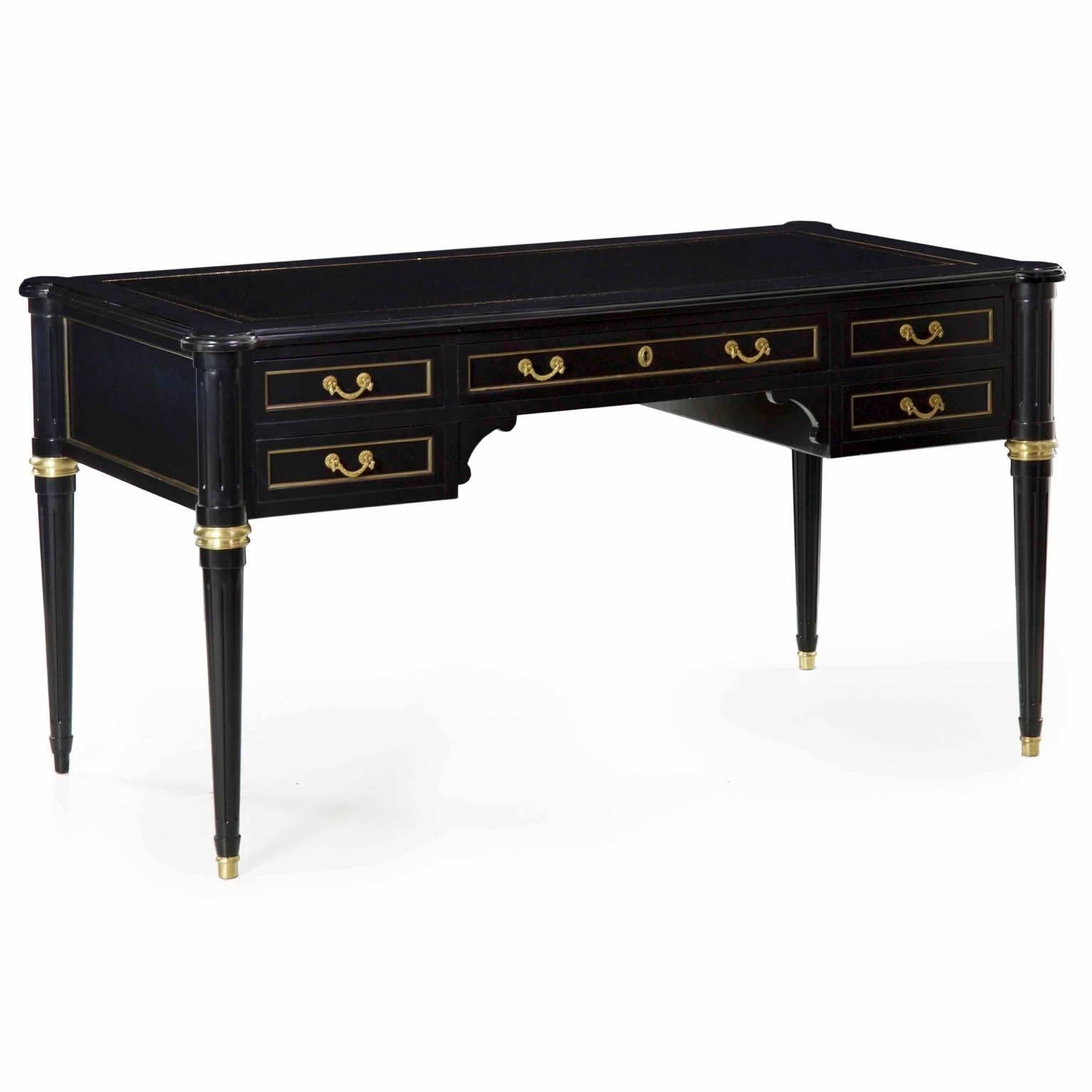 An attractive writing desk in the Louis XVI taste, this piece was likely crafted in the last thirty years or thereabouts and remains in excellent condition throughout. The black lacquer surface contrasts beautifully against the brass rings, sabots