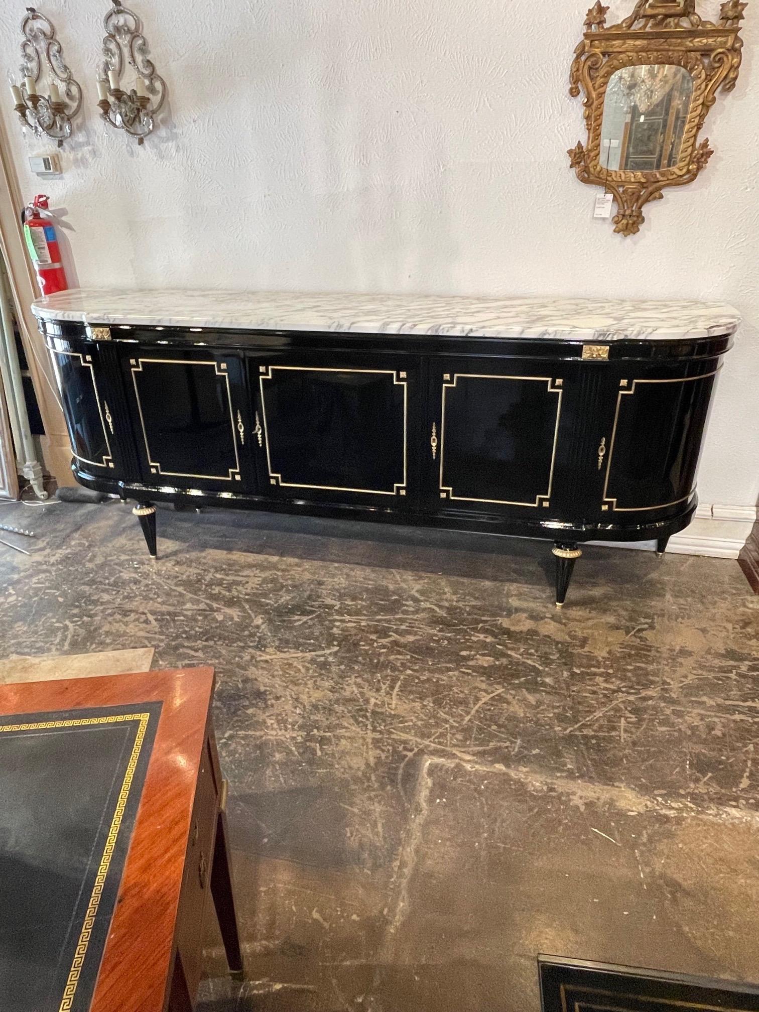 Gorgeous French Louis XVI style black lacquered side board with Marble top and gilt brass trim. Superb quality and tons of storage as well as an expansive serving area. Also, the inside is beautiful as well. Creates a very impressive sleek look!