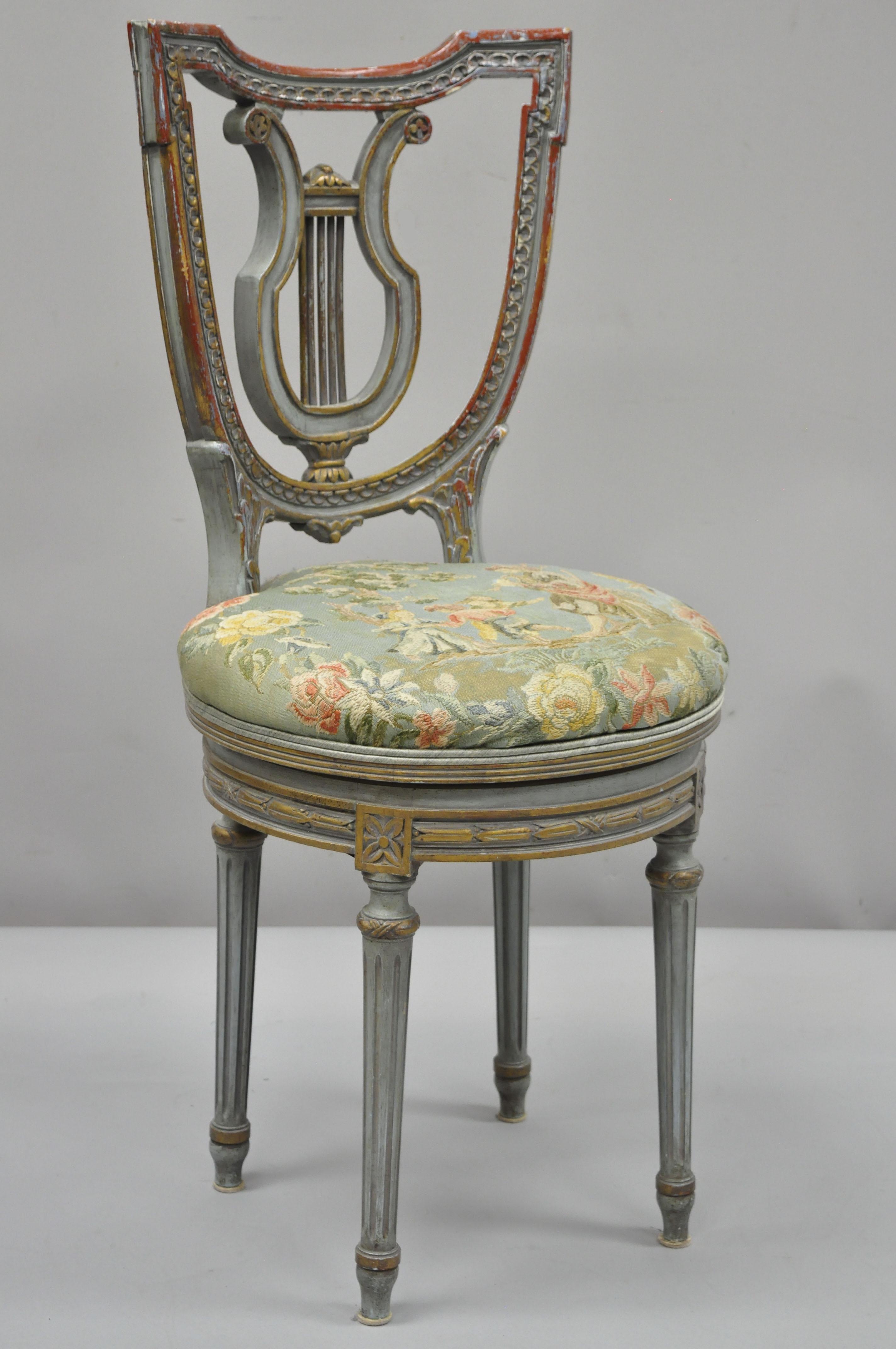 Vintage French Louis XVI style blue and red painted harp lyre back swivel accent vanity chair. Item features round swivel seat with figural tapestry upholstery, finely carved details, blue and red parcel gilt, distress painted finish, carved 