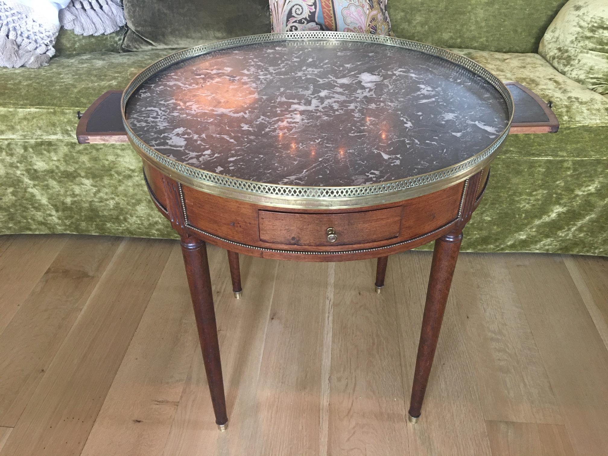 French Louis XVI style Bouillotte table with a marble top, drawers, and a brass gallery, 19th century.
  