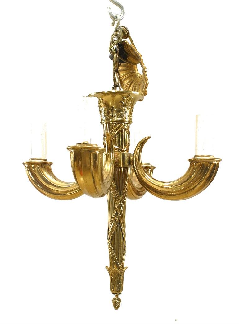Lustre en laiton de style Louis XVI (20ème siècle) avec 4 bras en forme de cornes d'abondance émanant d'un poteau central cannelé avec une base en forme de fleuron et un baldaquin.