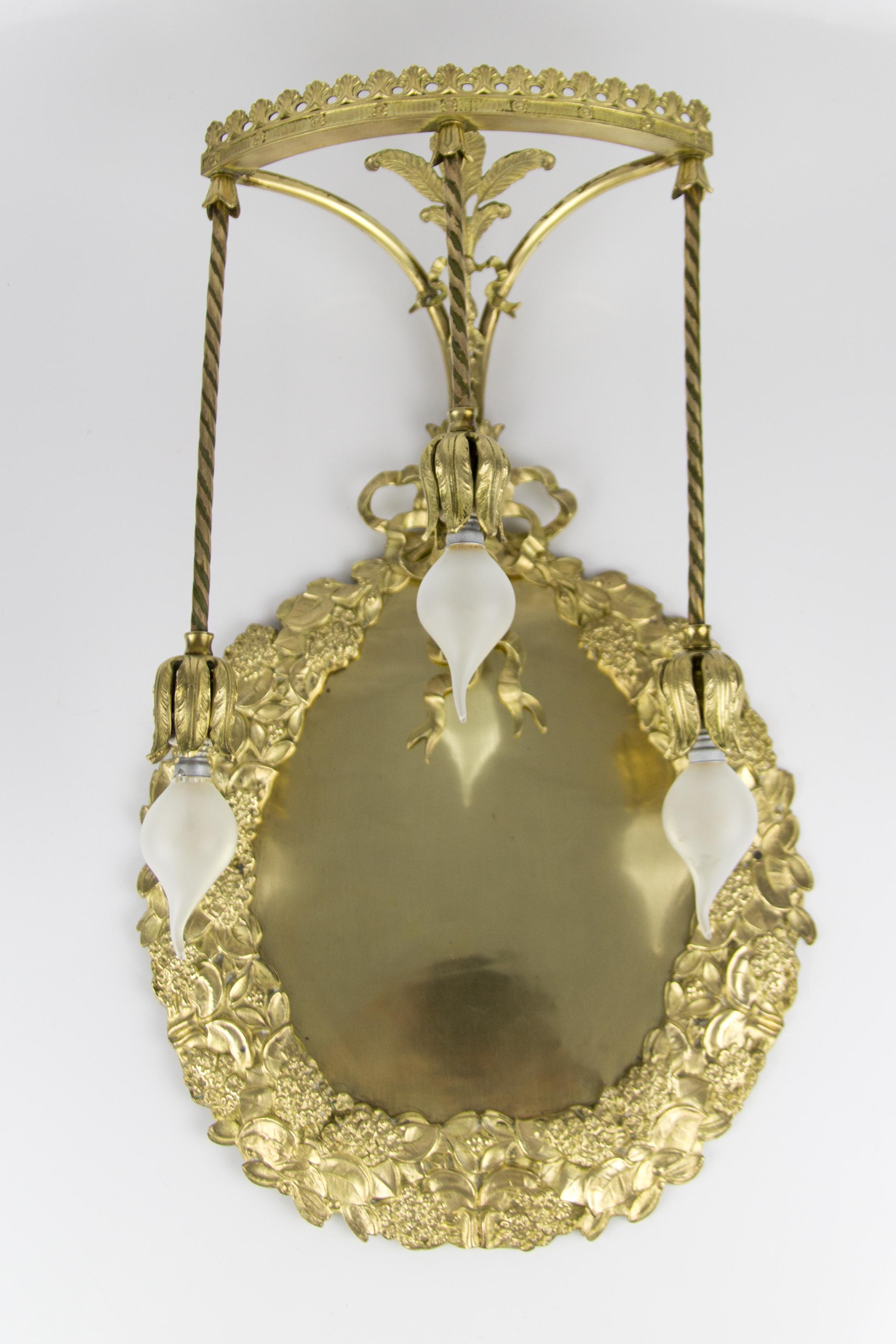 Maravilloso y muy inusual aplique de bronce y latón estilo Luis XVI, fabricado en Francia, principios del siglo XX. Decorada con una corona de laurel, que se ata con una cinta anudada. Decorado por encima con hojas de acanto y palmetas. Tres brazos