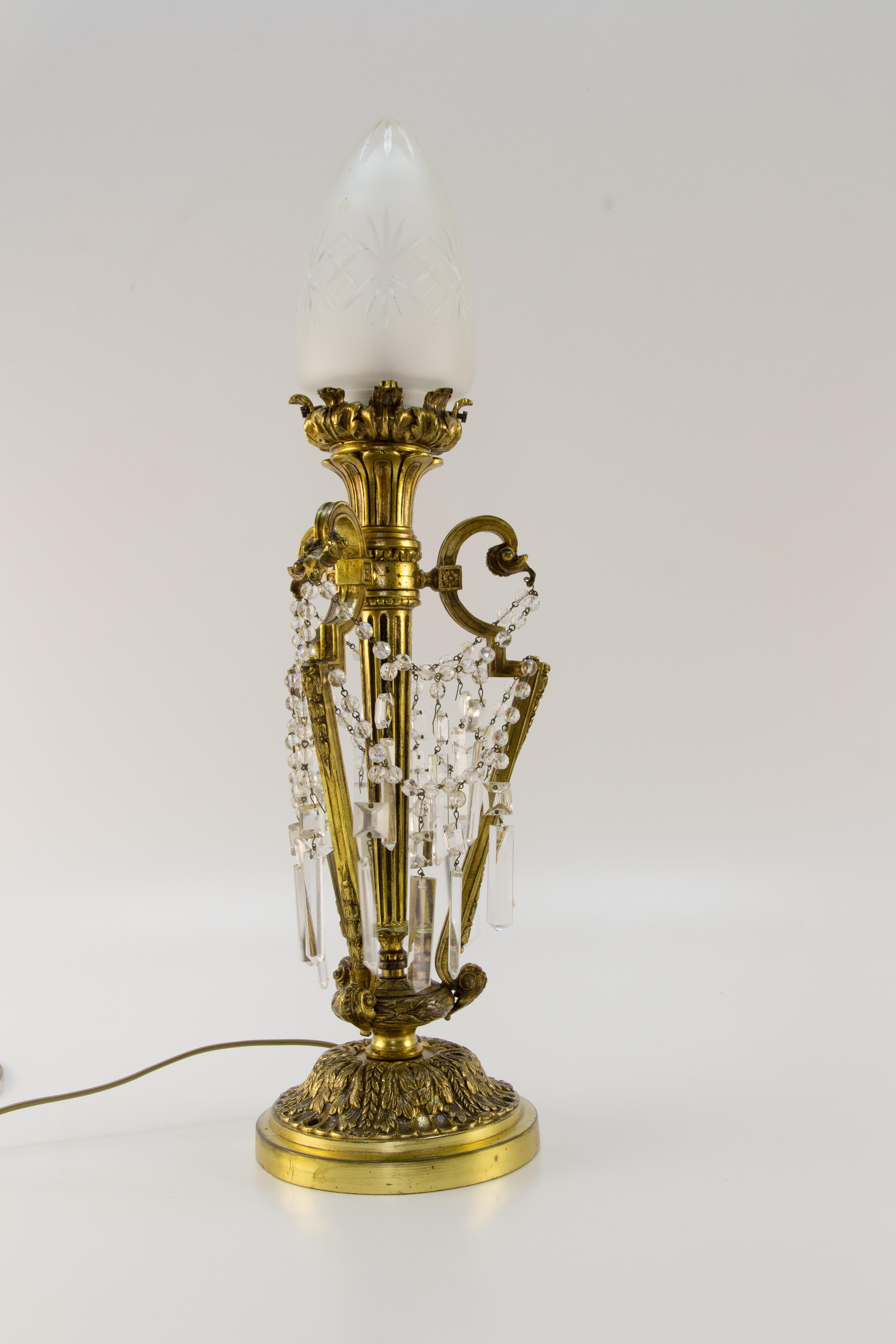 French Louis XVI style bronze and crystal newel post lamp with frosted glass shade and original E 27 socket with new wiring. France, 1920’s.
Nicely decorated with bronze decors in a form of acanthus leaves and crystal glass beaded chains and