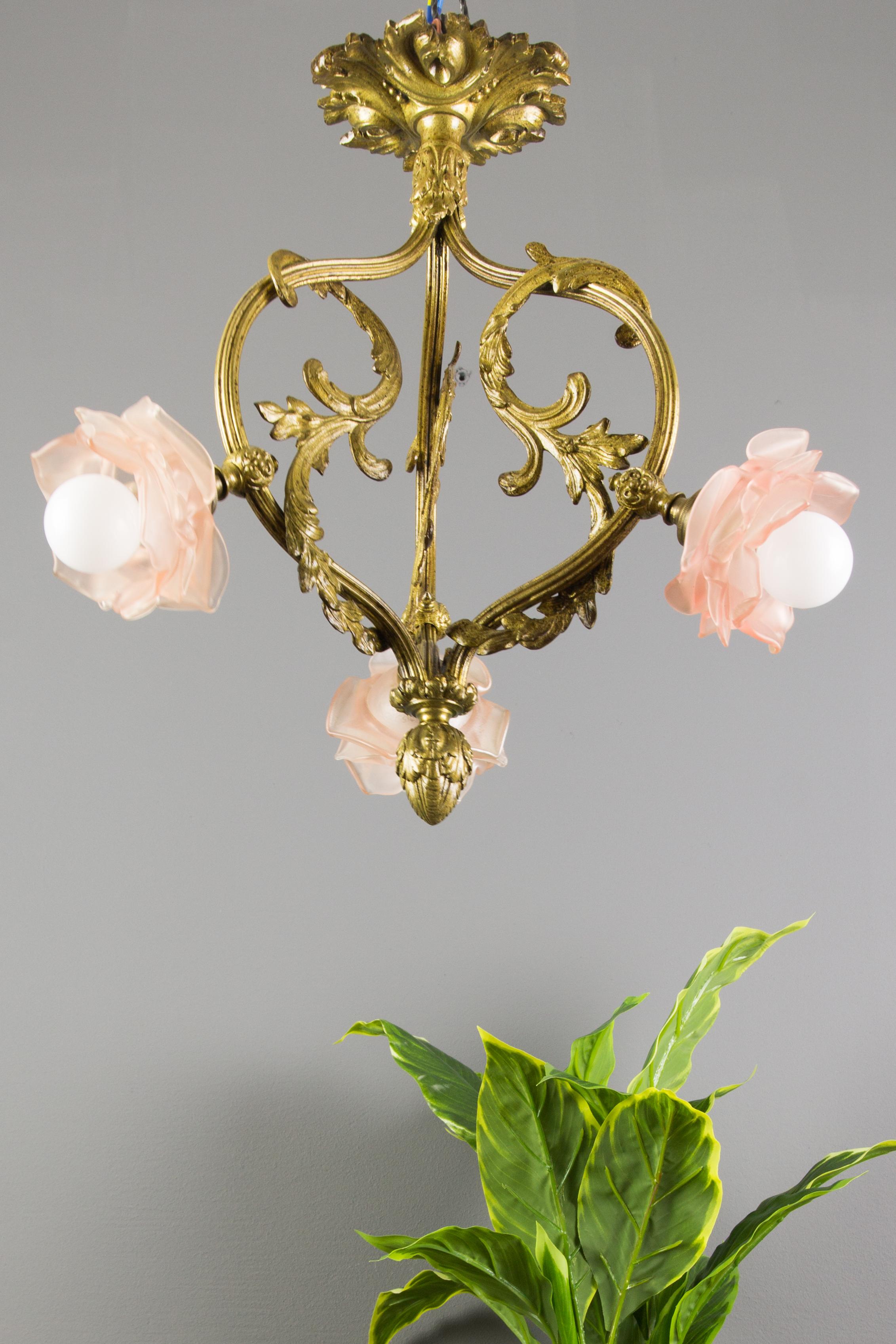 This adorable Louis XVI style French bronze light fixture is decorated with acanthus leaves and has three arms, each with floral shaped frosted glass shade. Three sockets for a B22 size light bulb.
This antique chandelier is very well suited for