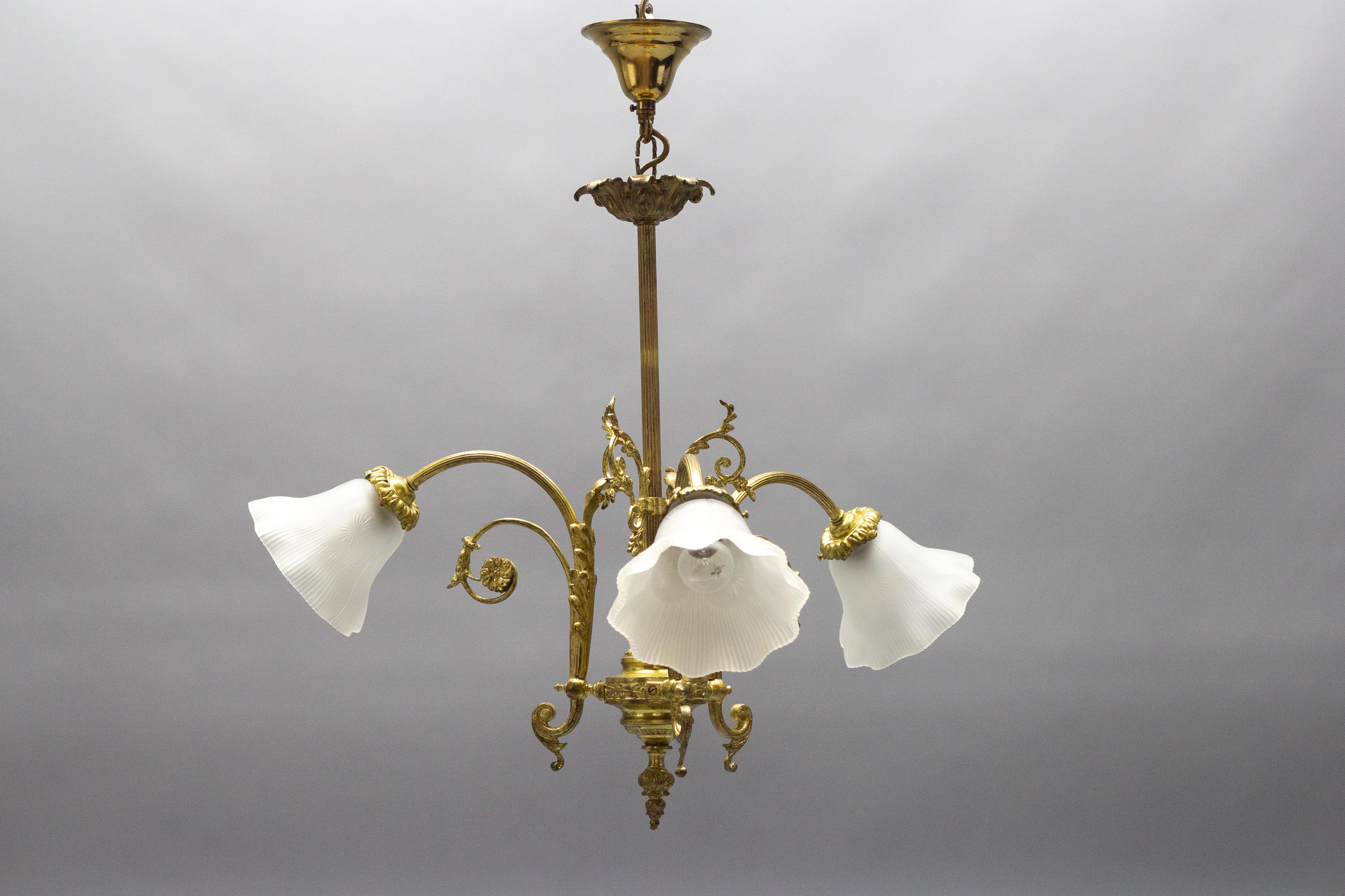 Lovely French Louis XVI style bronze and brass chandelier with three bronze arms each with frosted glass lamp shade and a socket for E27 (E26) light bulb. France, 1920s.
Measures: Diameter: 69 cm / 27.16 in, diameter without glass shades: 50 cm /