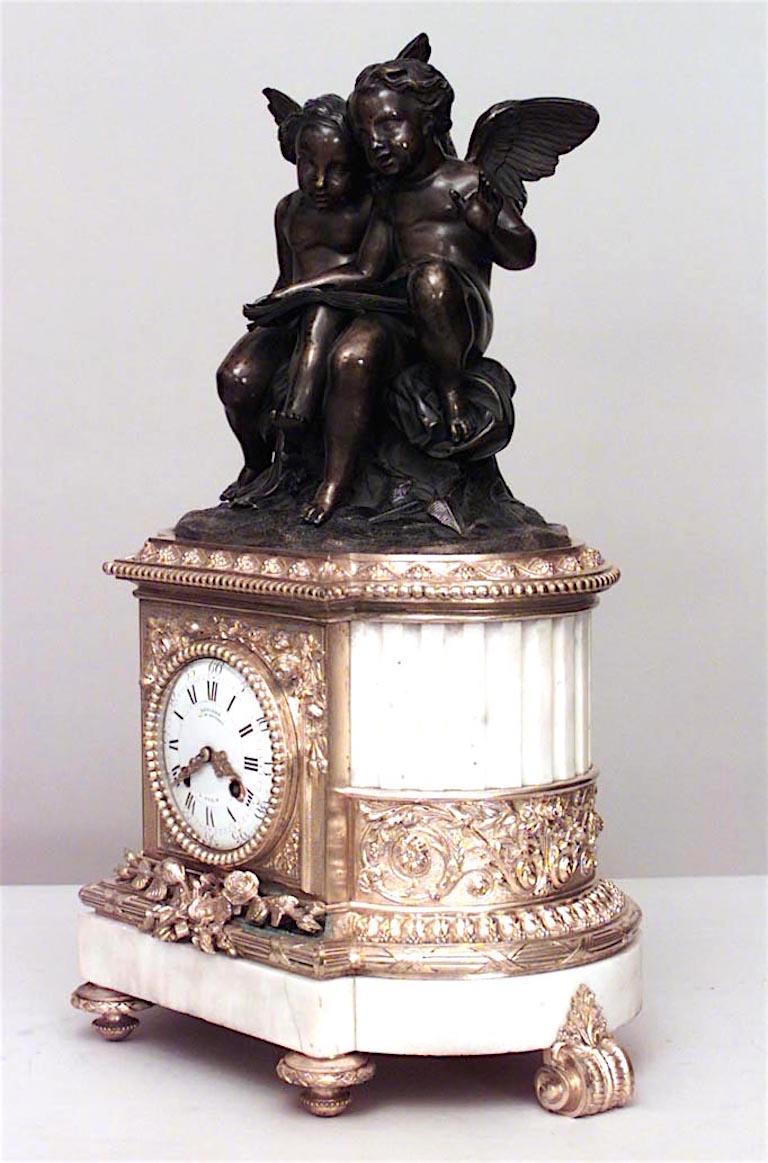French Louis XVI-style (19th Century) bronze dore and white marble oval shaped mantel clock with 2 cupids reading book at top. (Not working)

