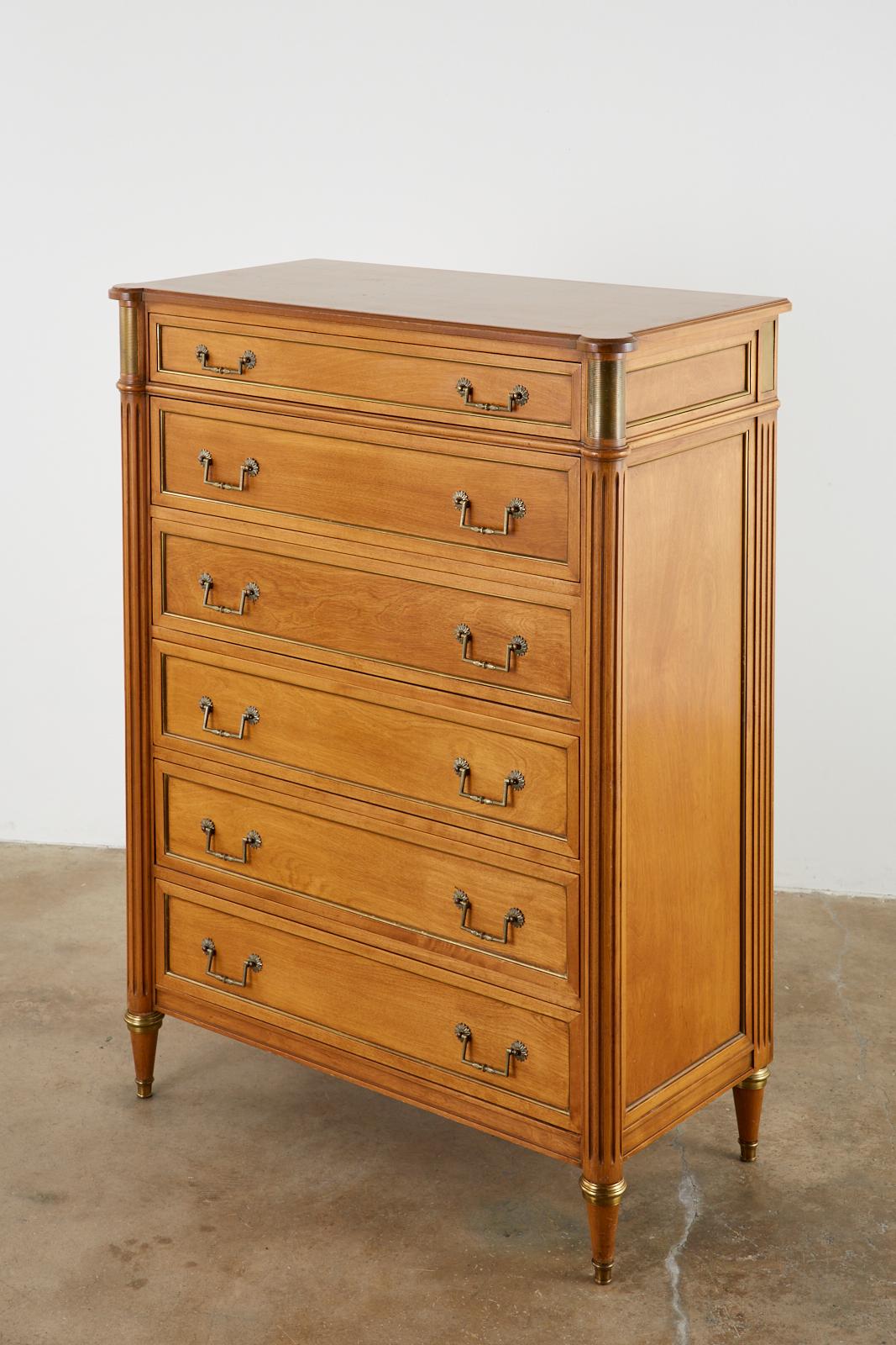 Gorgeous French mahogany tallboy dresser or chest of drawers made in the neoclassical Louis XVI taste. The case is embellished with brass accents on the side panels and drawers. The front of the case has fluted column style corners with bronze