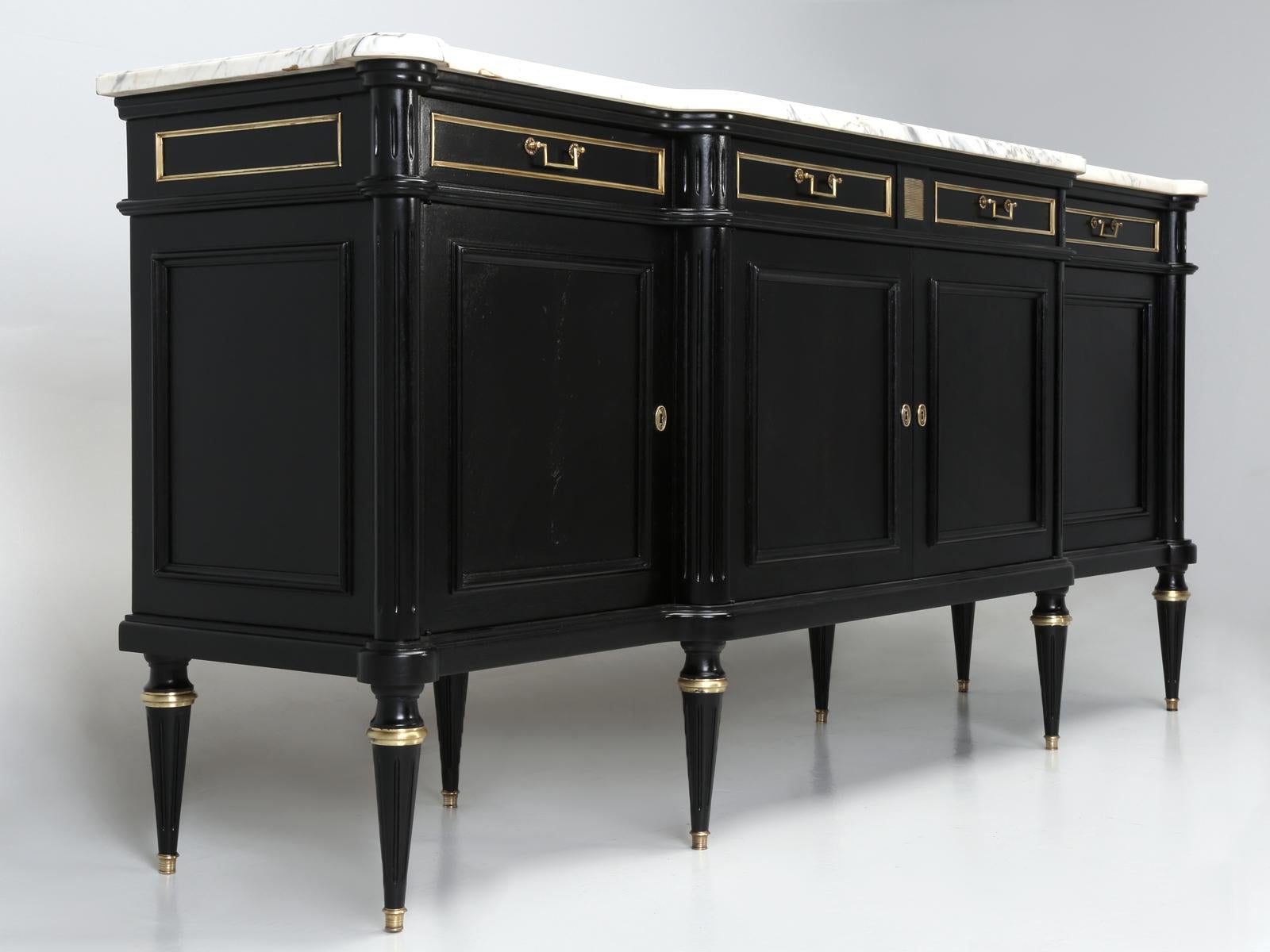 French Louis XVI style buffet with an exquisite marble top. Our Old Plank finishing department scraped, sanded and removed every inch of the old clear-coating and applied an old fashion ebonized finish. Look closely and you will still see the grain