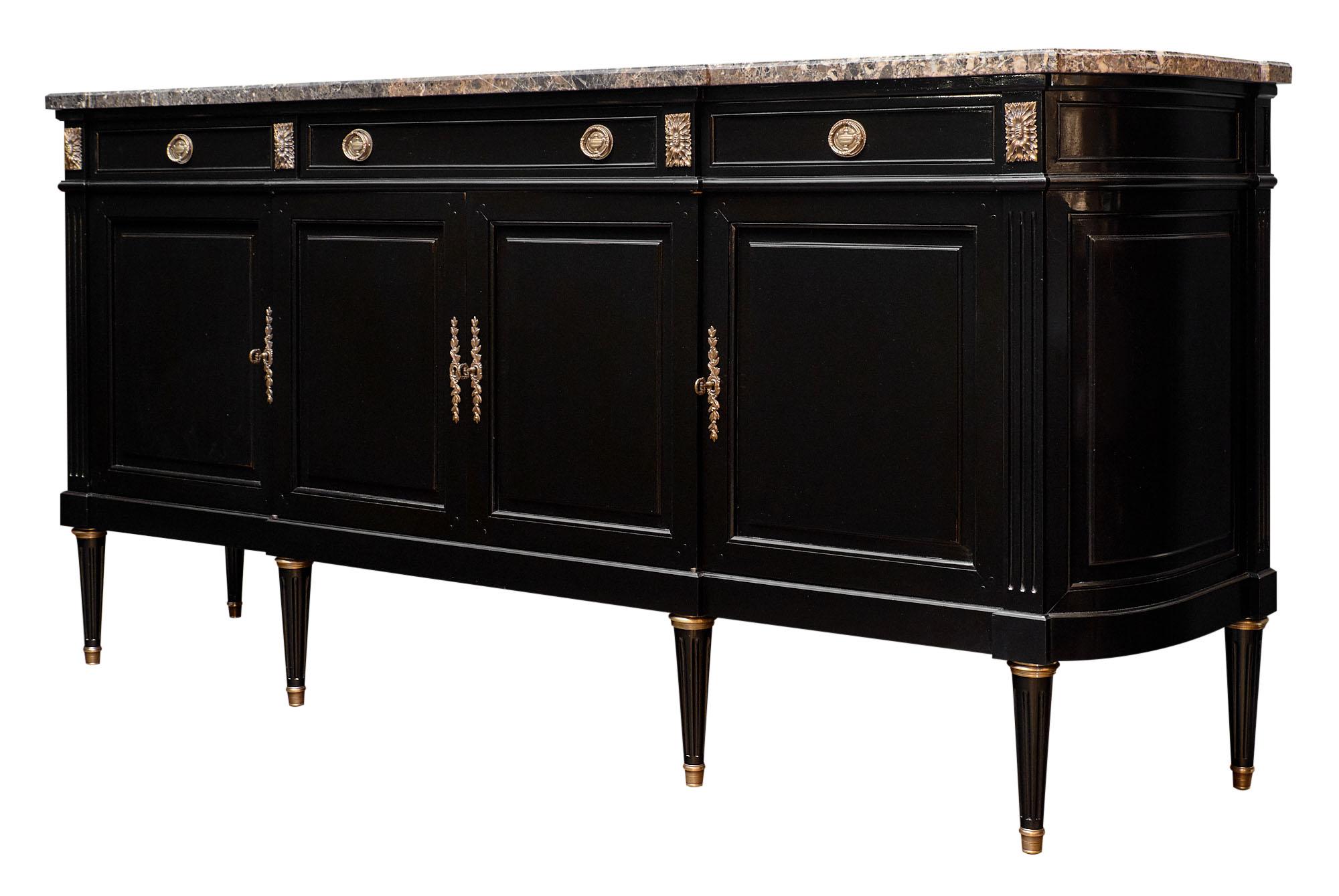 Louis XVI style French buffet with Saint Anne marble top. This important enfilade made of mahogany has its original marble intact, and features the perfect amount of gilt brass decor and hardware. We love the fluted details and French polish finish.