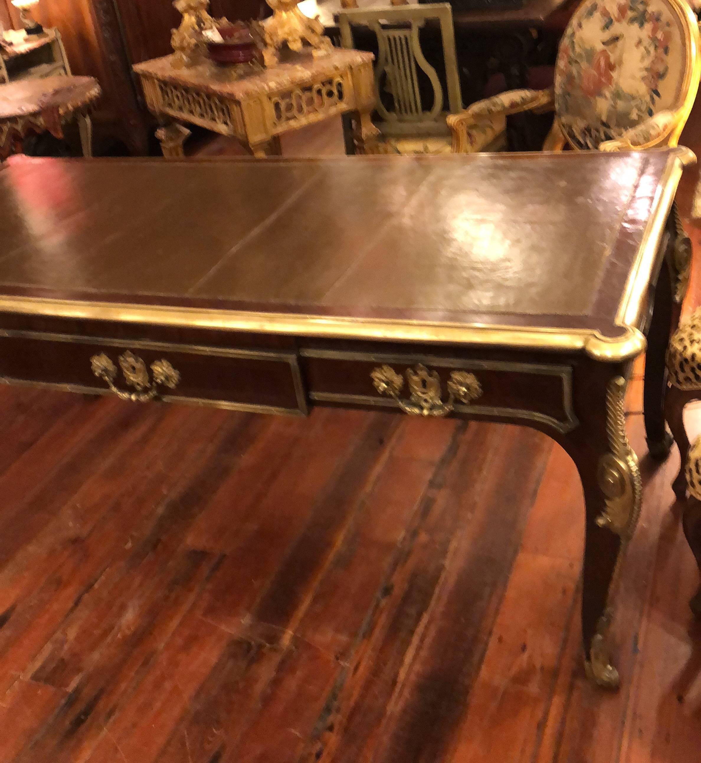 French Louis XVI style bureau plat, mahogany with bronze mounts and leather top.
Three drawer bureau with false drawers on reverse side.