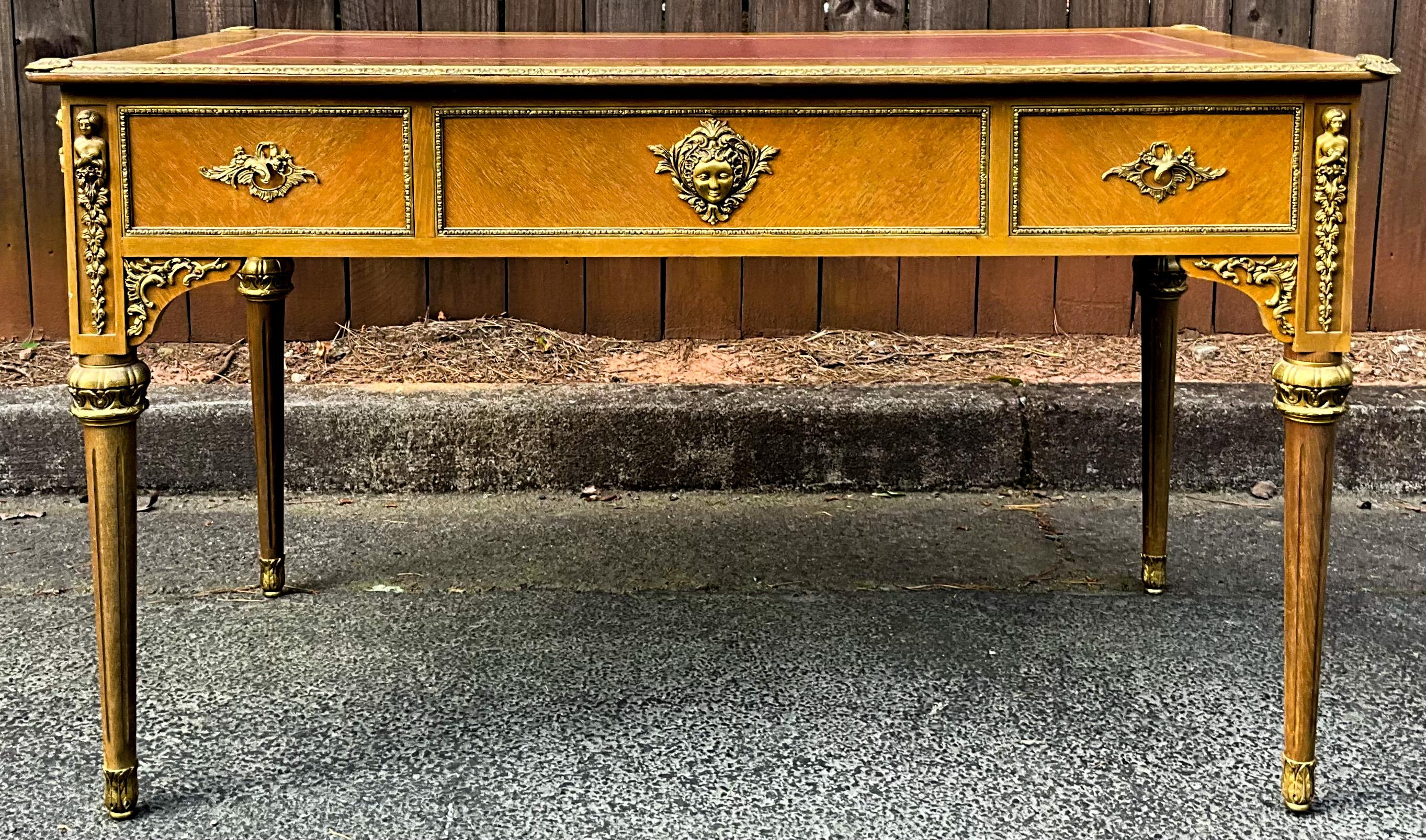 This is a lovely French Louis XVI style bureau plat dating to the 1940s. It has a red tooled leather top and bronze appointments. The desk has a single dovetailed drawer and key with a knee clearance of 24 inches. It is unmarked and in nice vintage