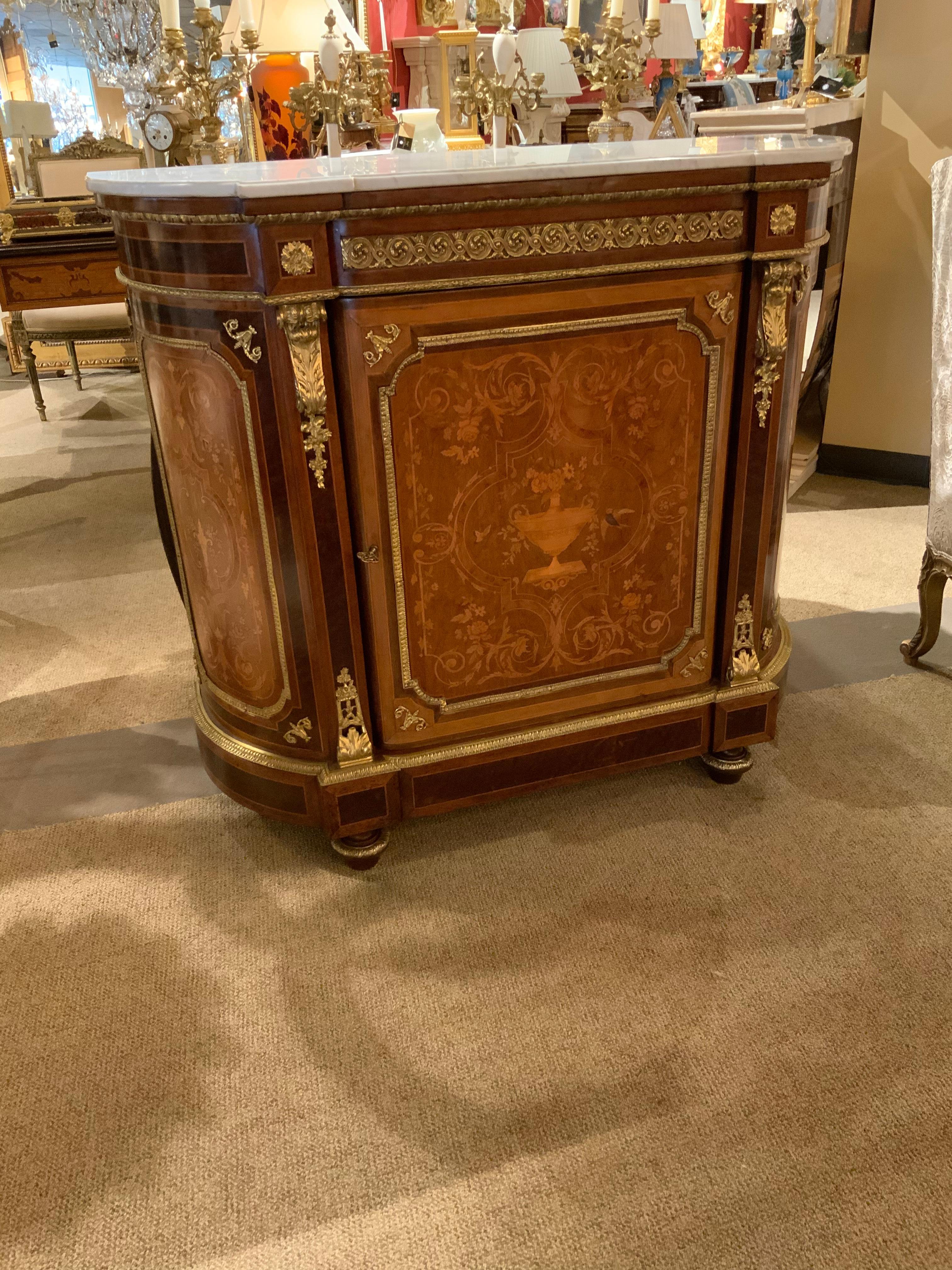 Exceptional quality and style. This is a gracefully curved cabinet with beautiful 
Inlay of fine and various woods. It has bronze dore mounts that are original 
The inlay design depicts floral, foliate designs with birds. It has two shelves
And