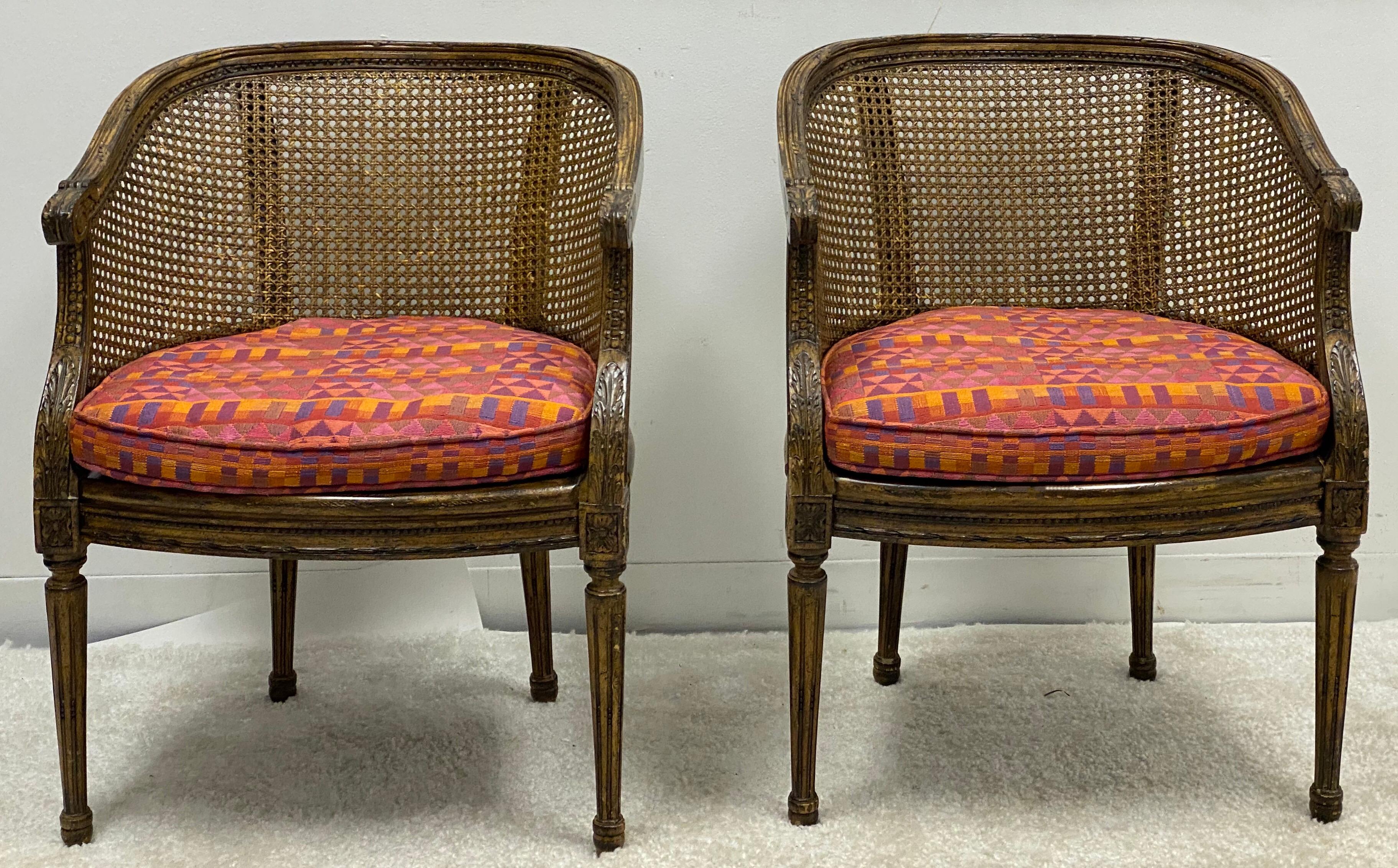 This is a lovely pair of French Louis XVI style caned barrel chairs attributed to Lewis Mittman. The cushion is vintage, and the chairs are unmarked.