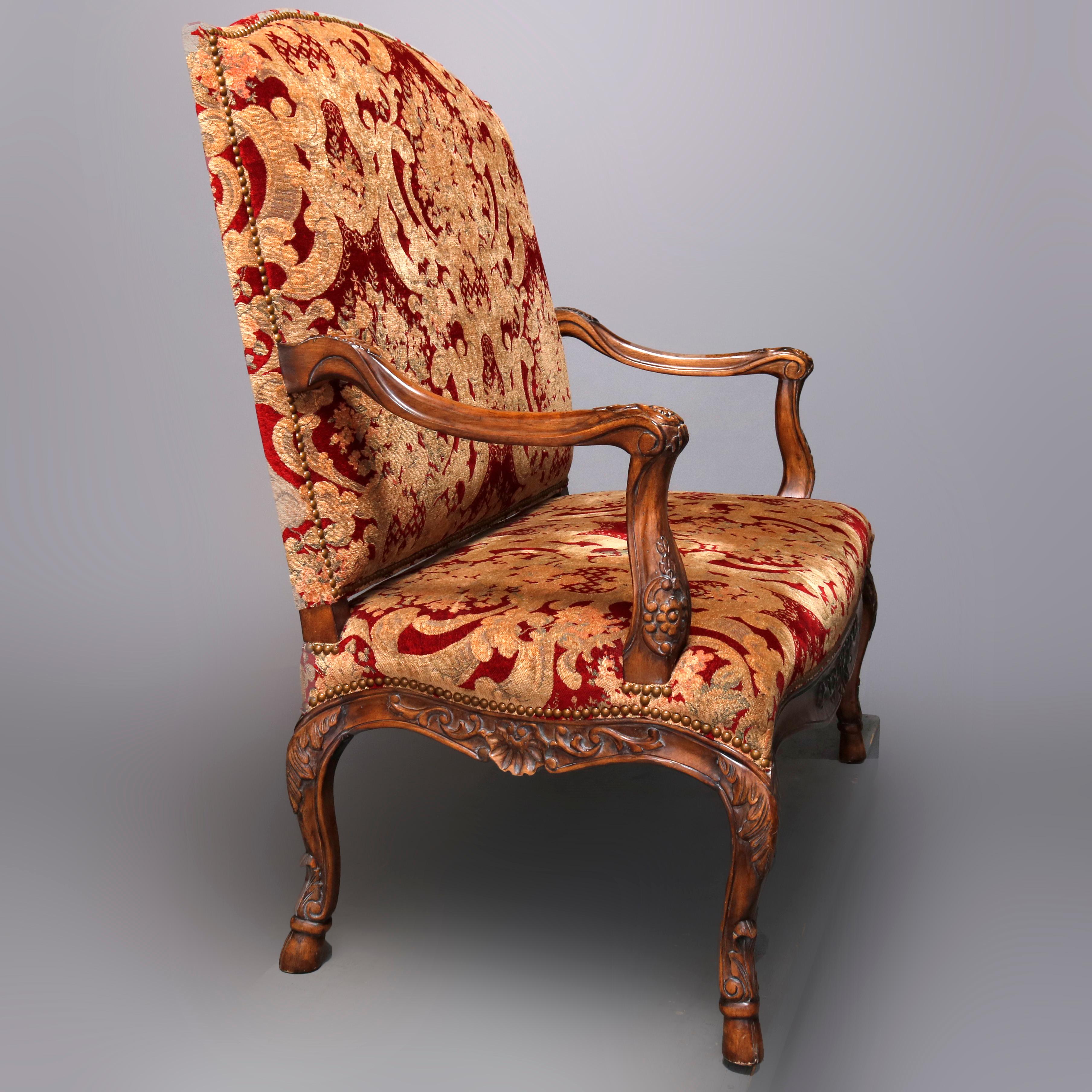 A French Louis XVI style settee offers upholstered high back and seat with carved fruitwood frame having scroll form arms draped with carved acanthus, skirt decorated with foliate and shell carvings, and raised on cabriole legs having acanthus
