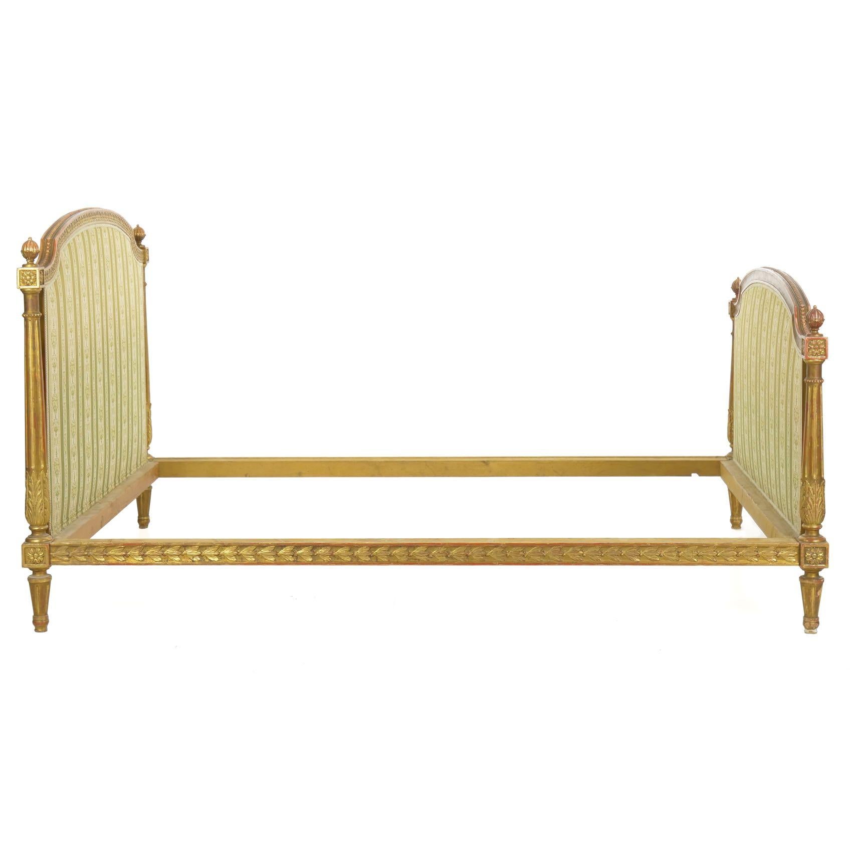 A product of the late 19th-early 20th century, every aspect of this exquisitely carved and gilded bed frame has been carefully designed and executed. It is covered in a relatively recent striped linen and comes with a matching spread (not pictured).