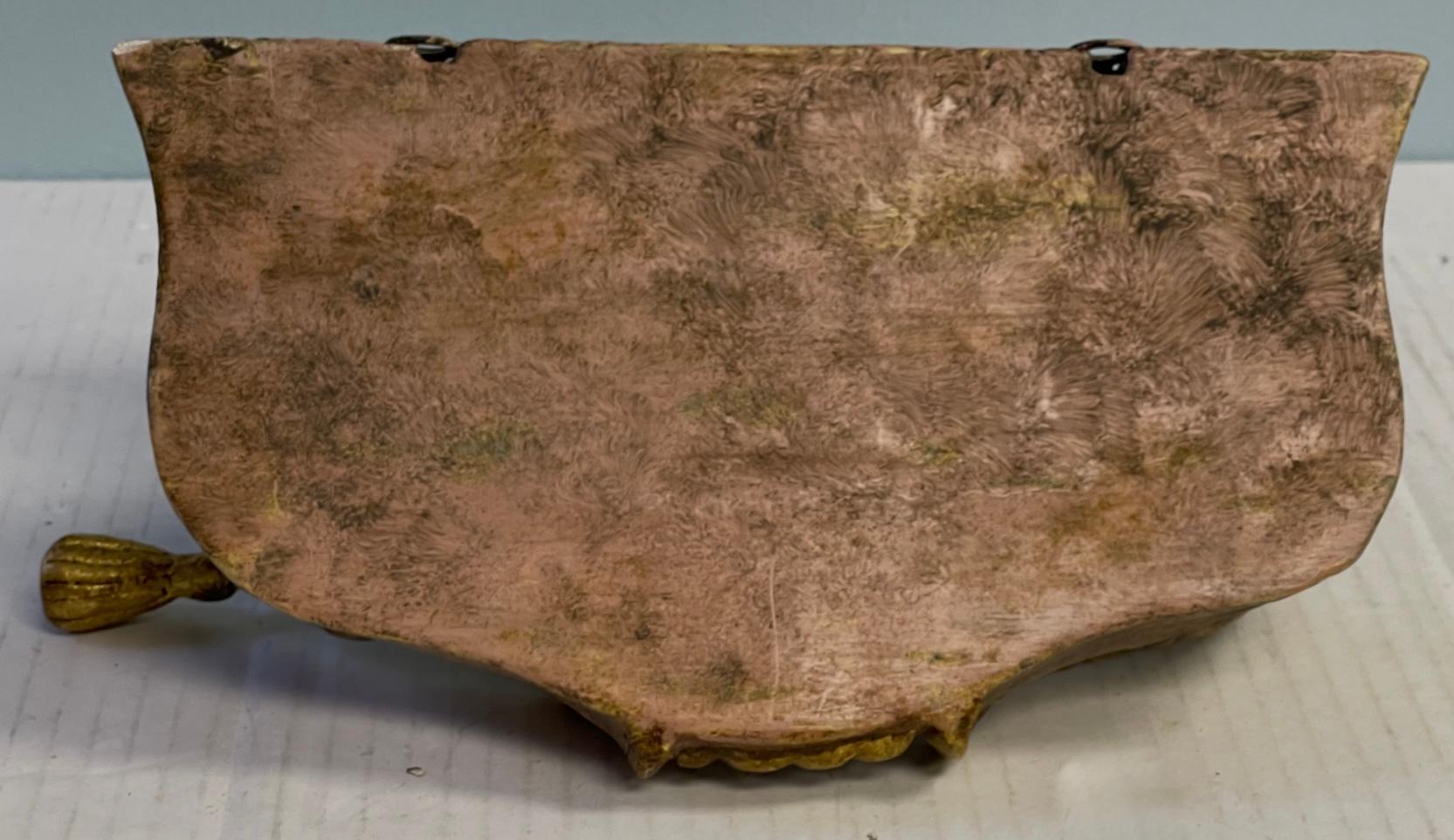 This is a charming Italian carved wood wall bracket with French Louis XVI styling. It depicts a cherub holding a draped and tassel “table”. It is in very good condition and unmarked. 