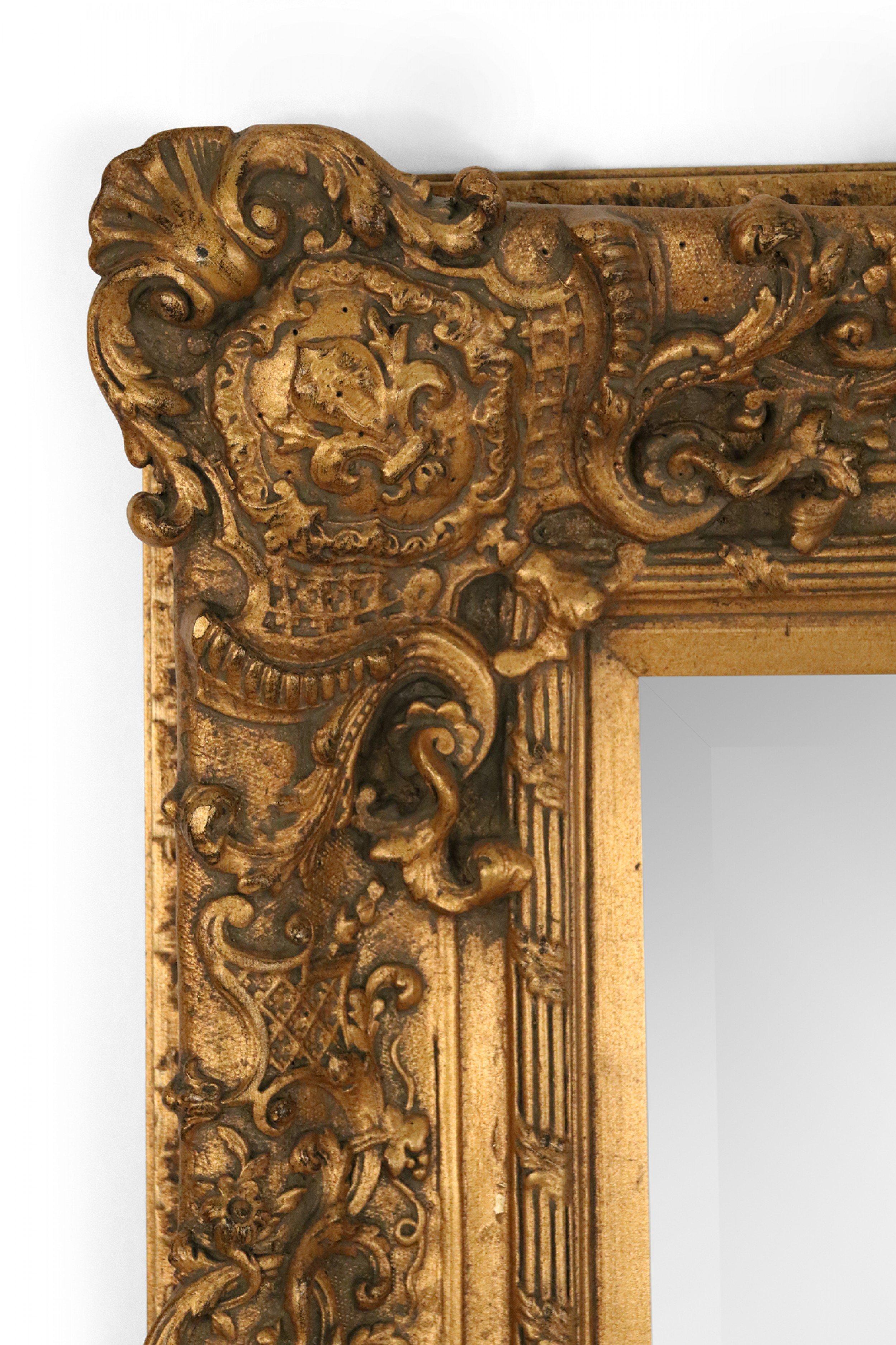French Louis XV style (19th-20th Century) carved rectangular giltwood wall mirror with fleur-de-lis motif in corners.